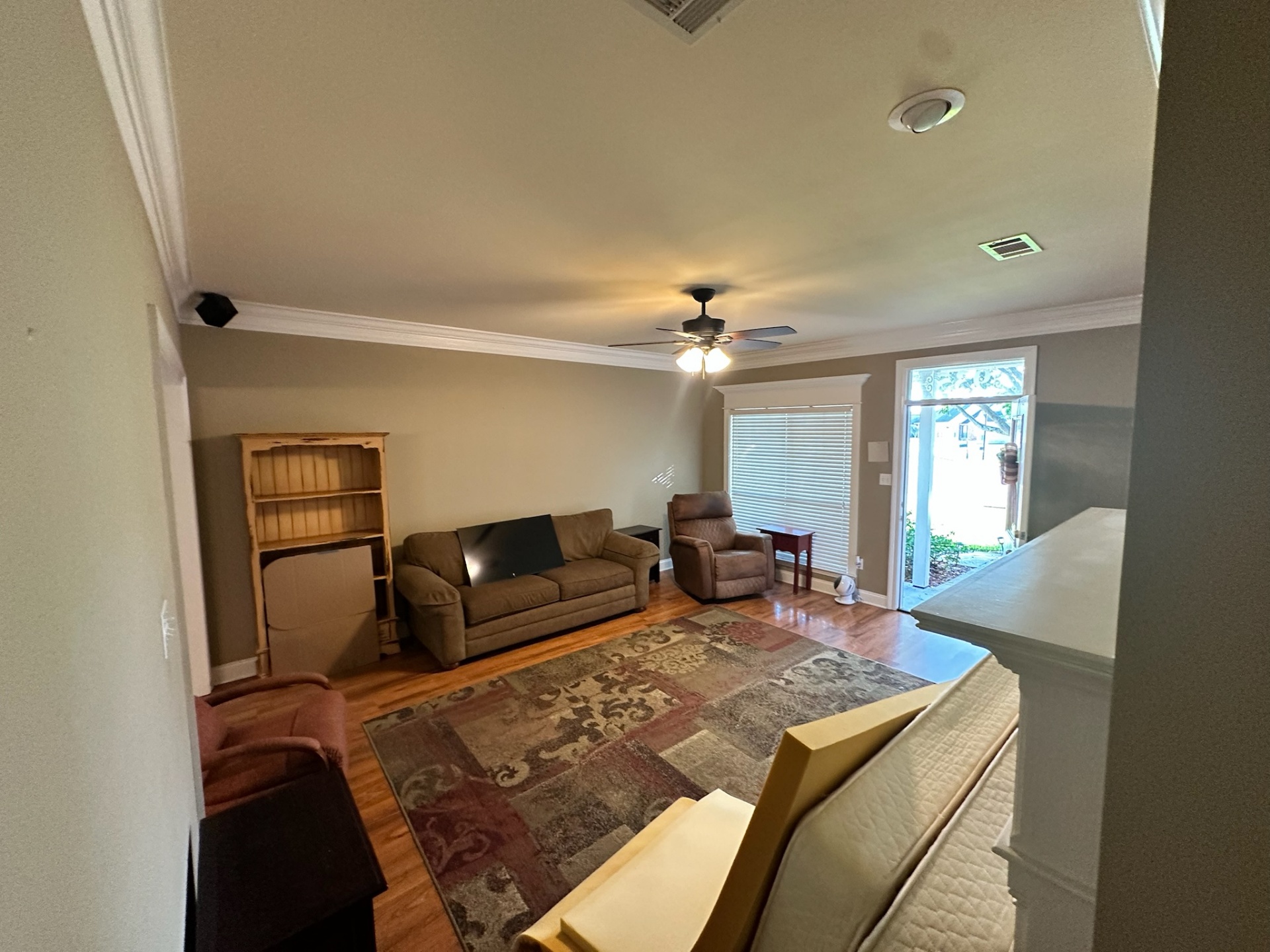 Before — second living area with aged wood flooring in Gonzales home