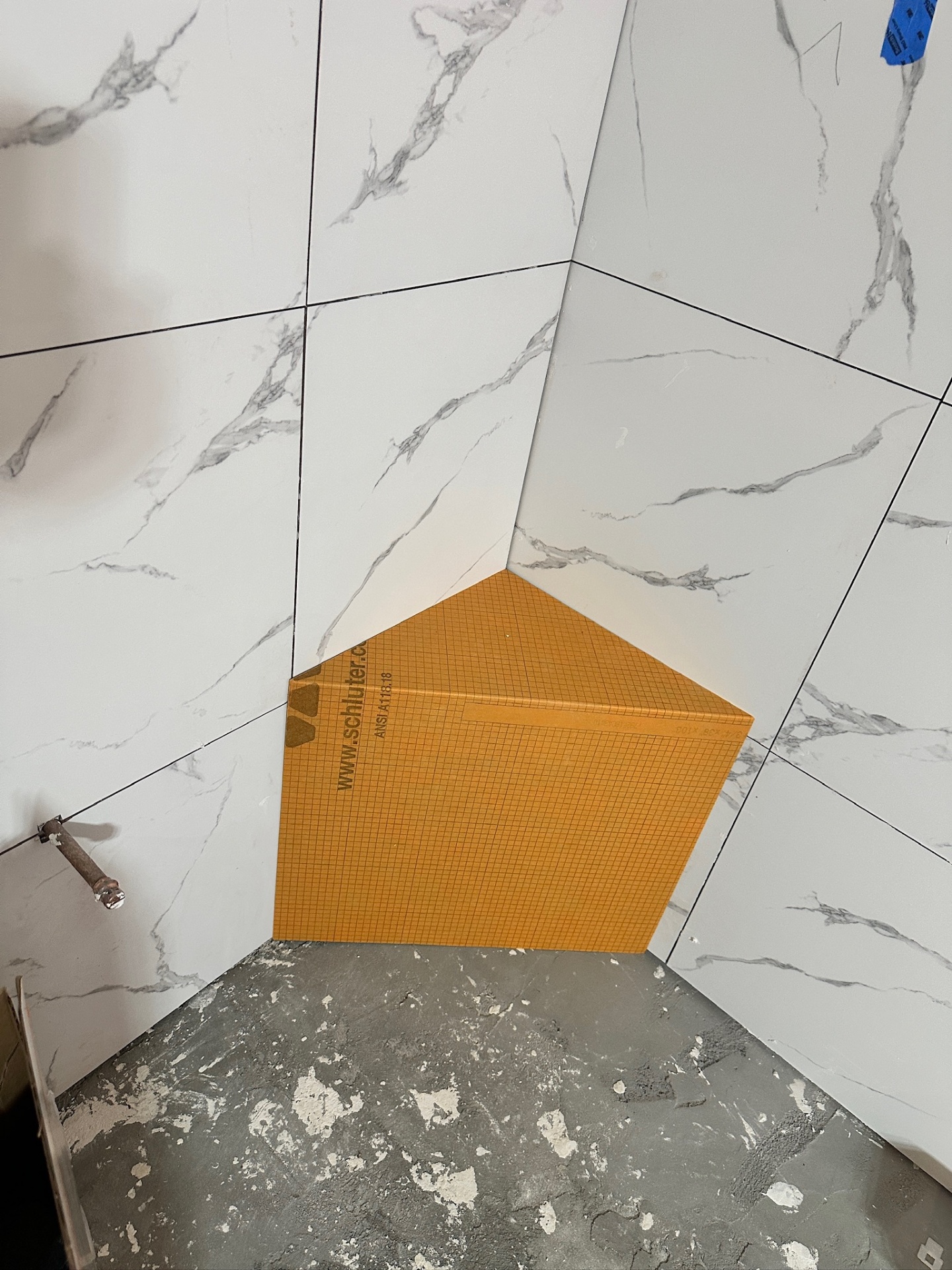Schluter Kerdi-Board corner shower bench set against fresh marble-look tile in Metairie master bath