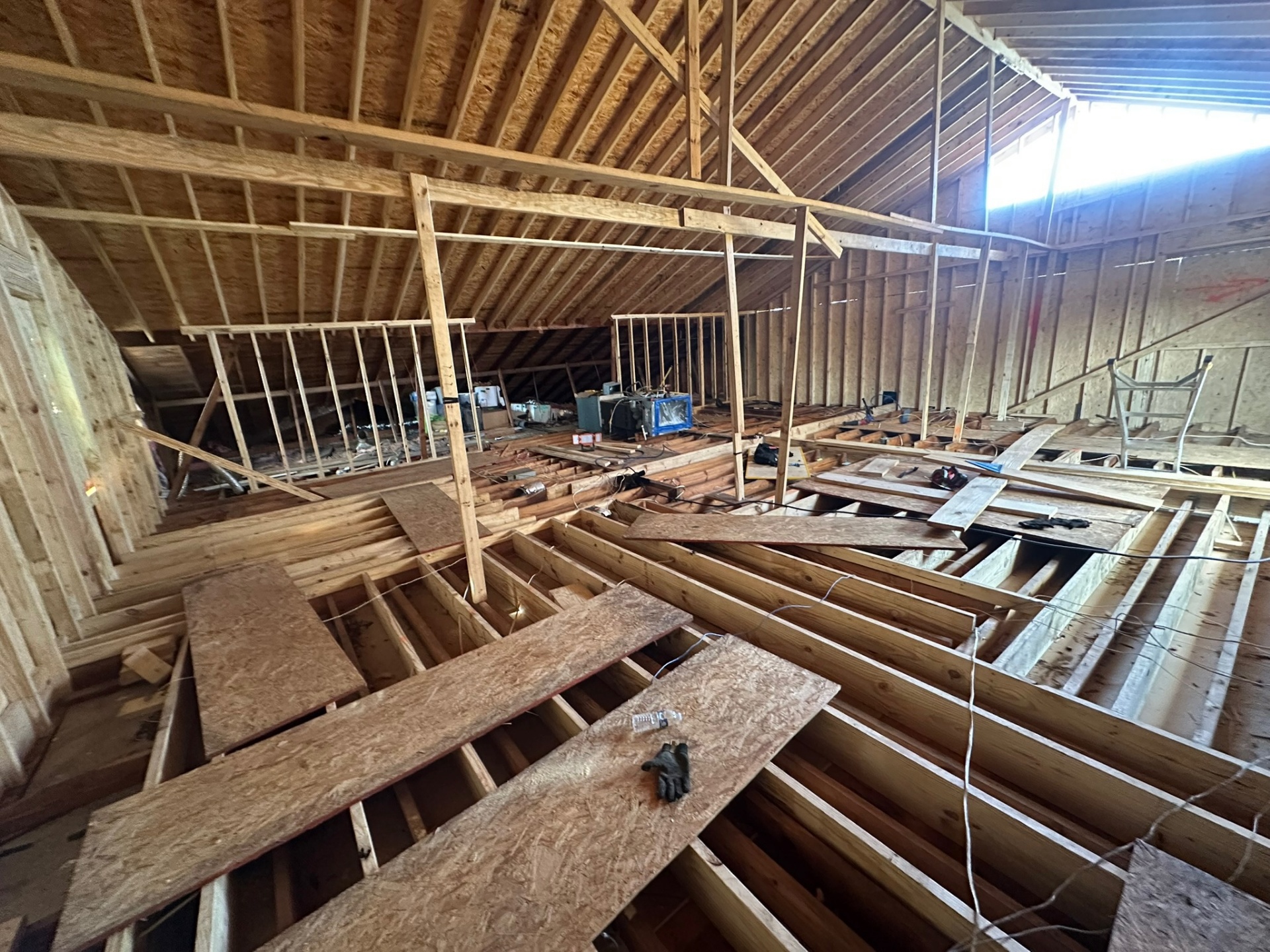 Wide interior view of Metairie second-floor framing with knee walls, ridge framing and exposed floor joists with OSB walking boards laid across for the crew