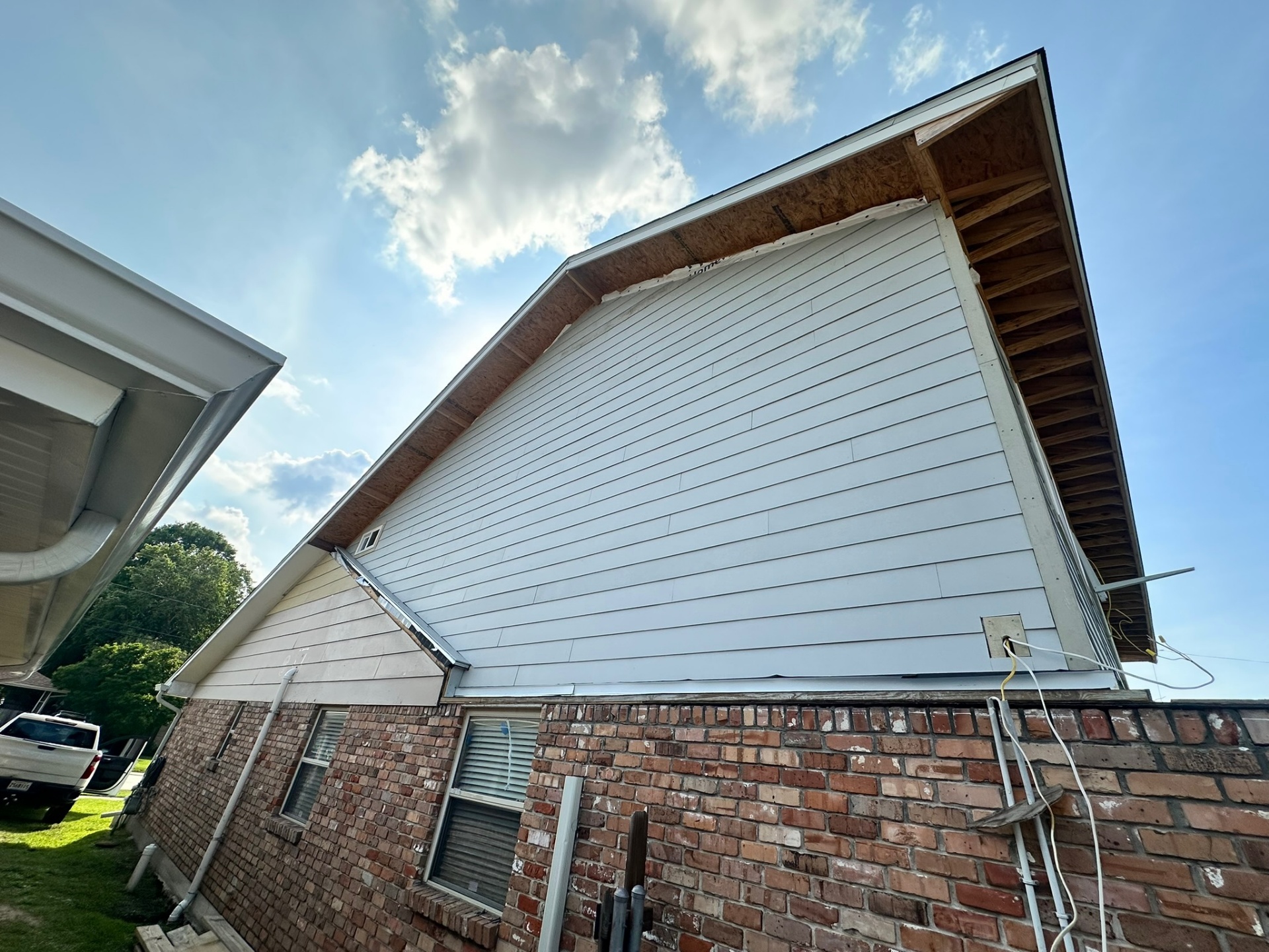 Wide rear gable Hardie siding install on second-floor addition Metairie Louisiana