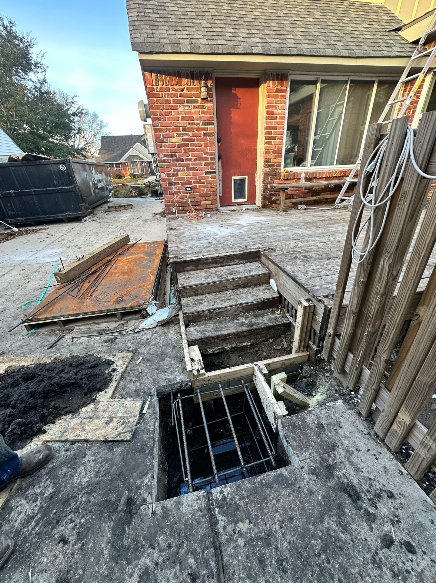 Wide rear elevation of Blanke Street Metairie home showing pier and footing work in progress during foundation reinforcement
