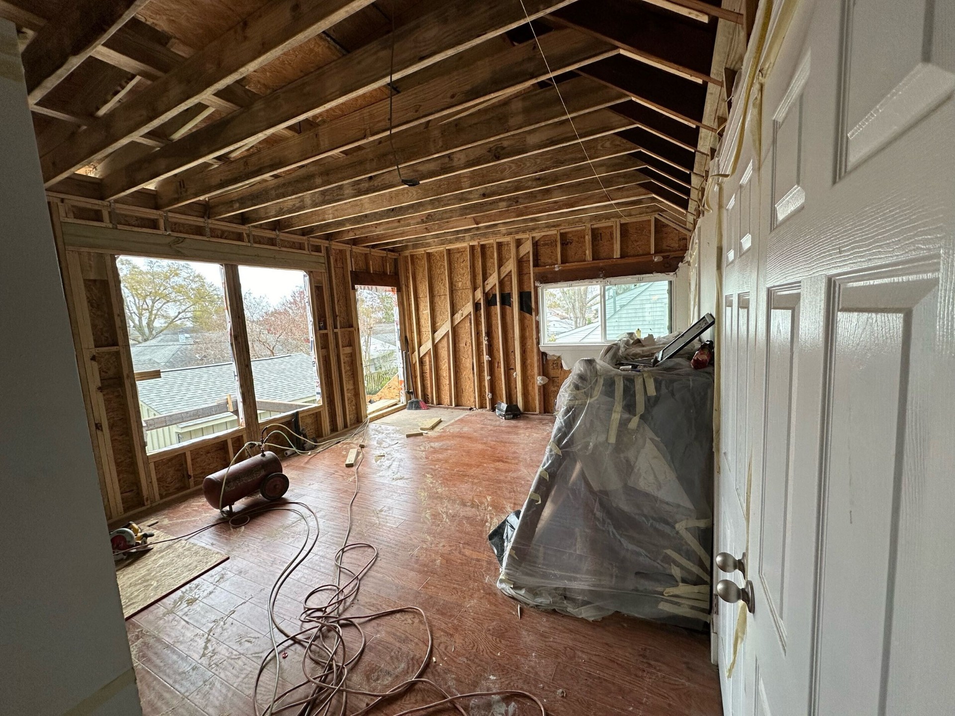 Interior of new second-story framing with cathedral ceiling rafters and new windows installed at Blanke Street Metairie home addition