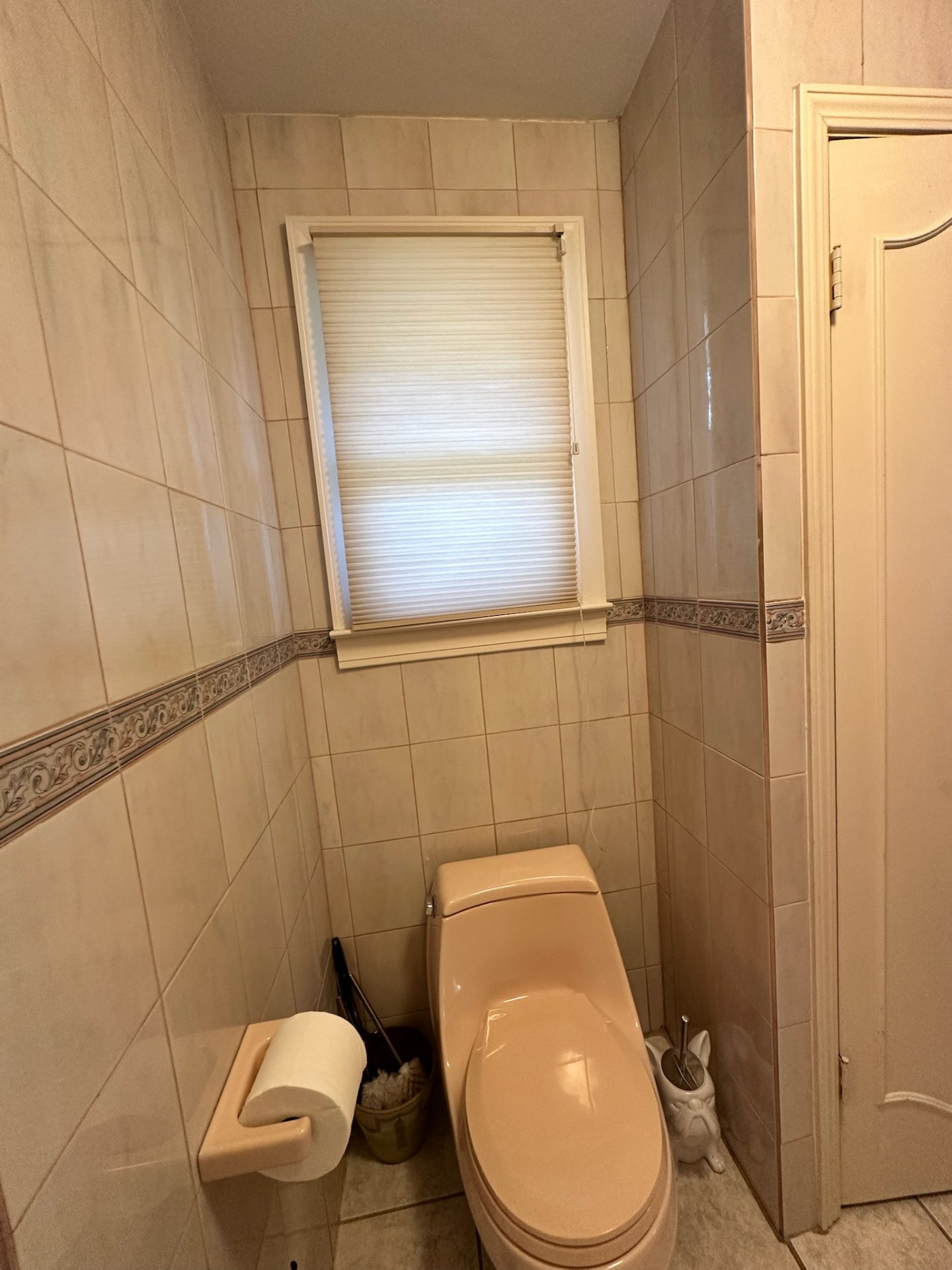 Before — separated peach toilet room with tile walls and floral border in Metairie master bathroom