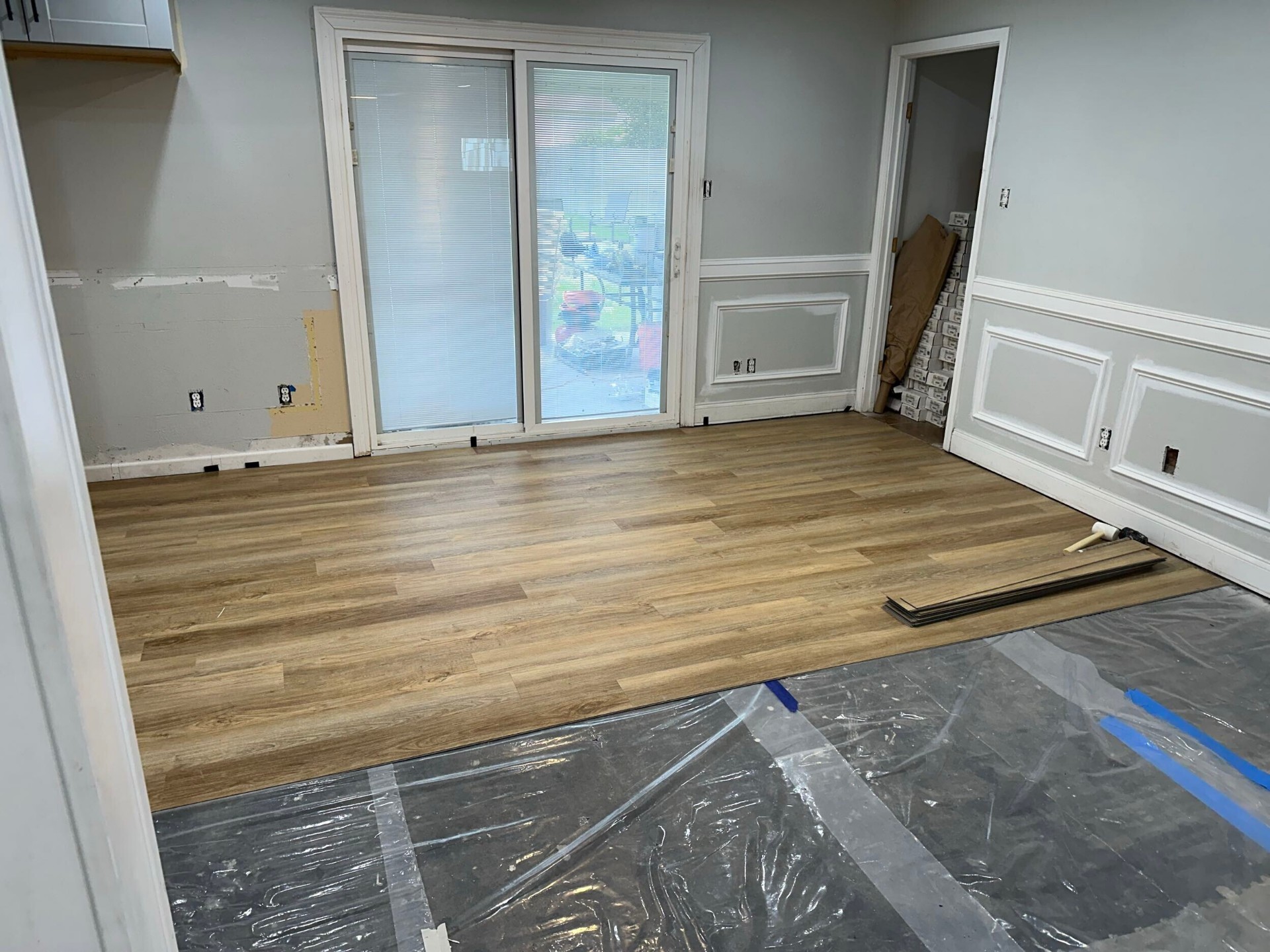 New wood-look laminate flooring installed near sliding patio door in interior of Blanke Street Metairie whole-home remodel