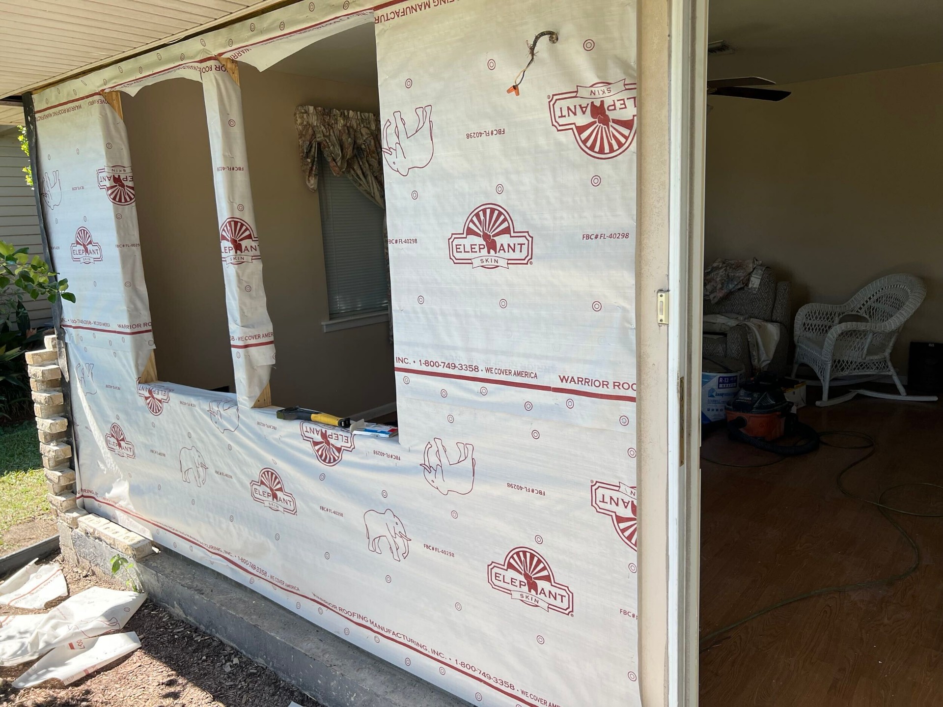 Exterior of Gretna home with Elephant Skin house wrap installed over new sheathing and three rough window openings ready for windows