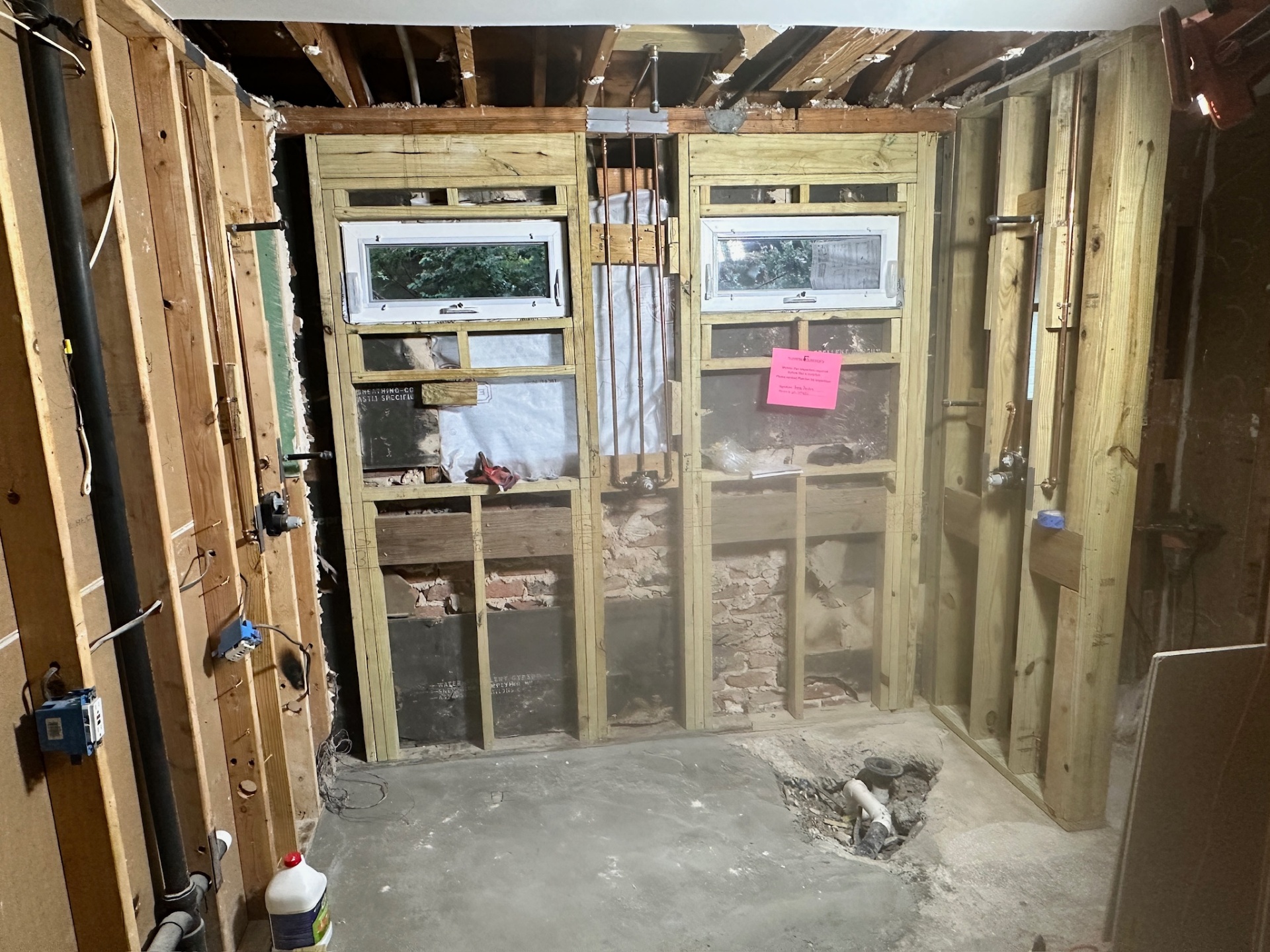 Master bath studs-out to bare framing with new pressure-treated framing and rerouted plumbing in Metairie