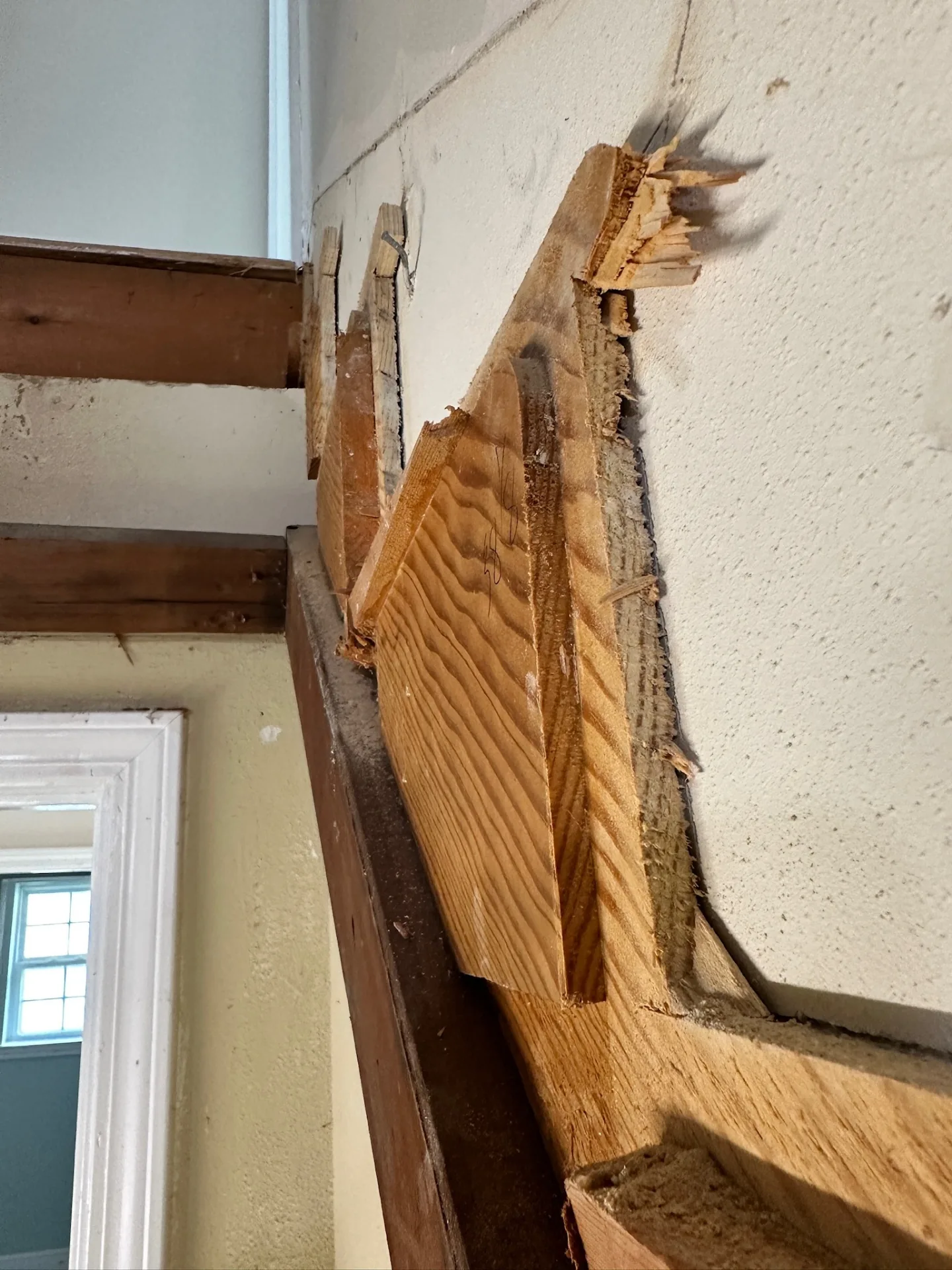 Damaged parapet framing and splintered wood at stucco wall of Blanke Street Metairie home, uncovered during whole-home remodel demo phase