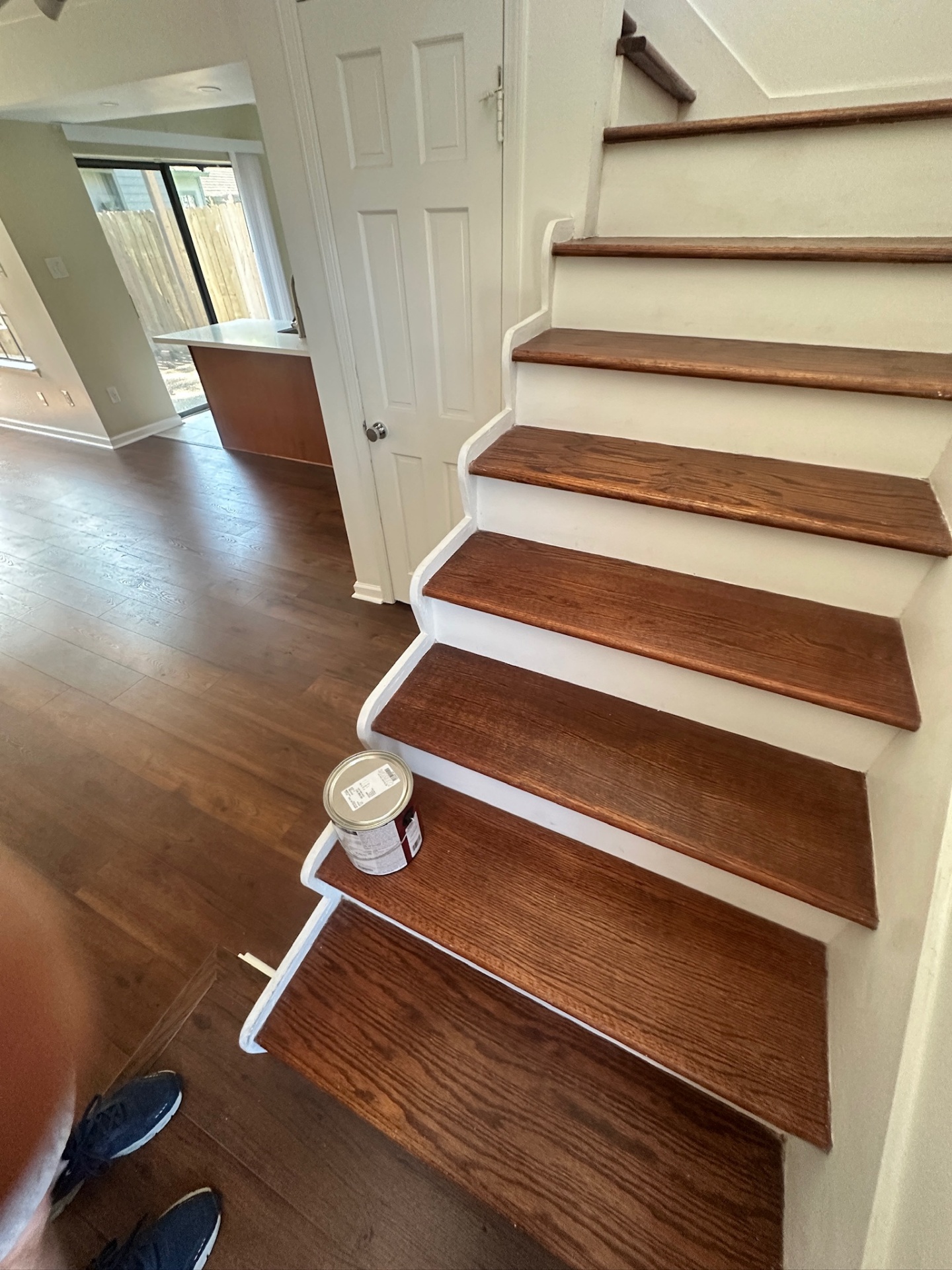 Side view of finished refinished oak stair treads with fresh white risers and stringers next to the newly built stair rail in a Kenner Louisiana home