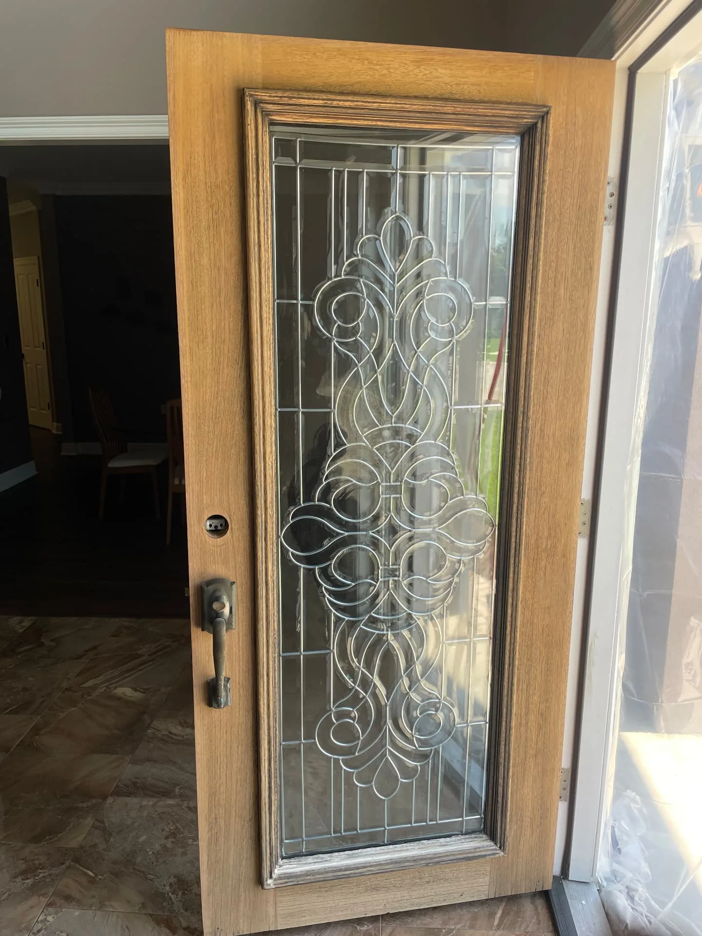Before — sun-faded mahogany entry door with worn finish in Destrehan Louisiana