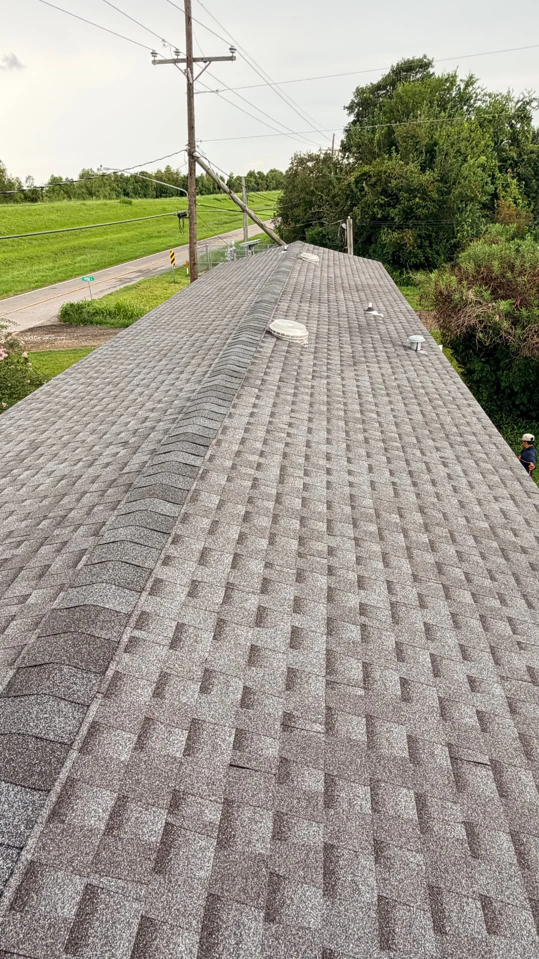 Finished architectural shingle roof with ridge cap on a Braithwaite Louisiana home after insurance roof replacement