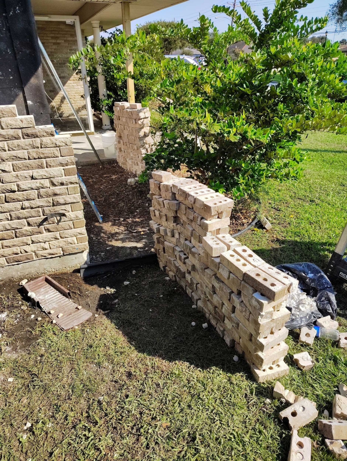 Color-matched replacement brick staged in the front yard of the Gretna home next to the existing brick veneer for the rebuild
