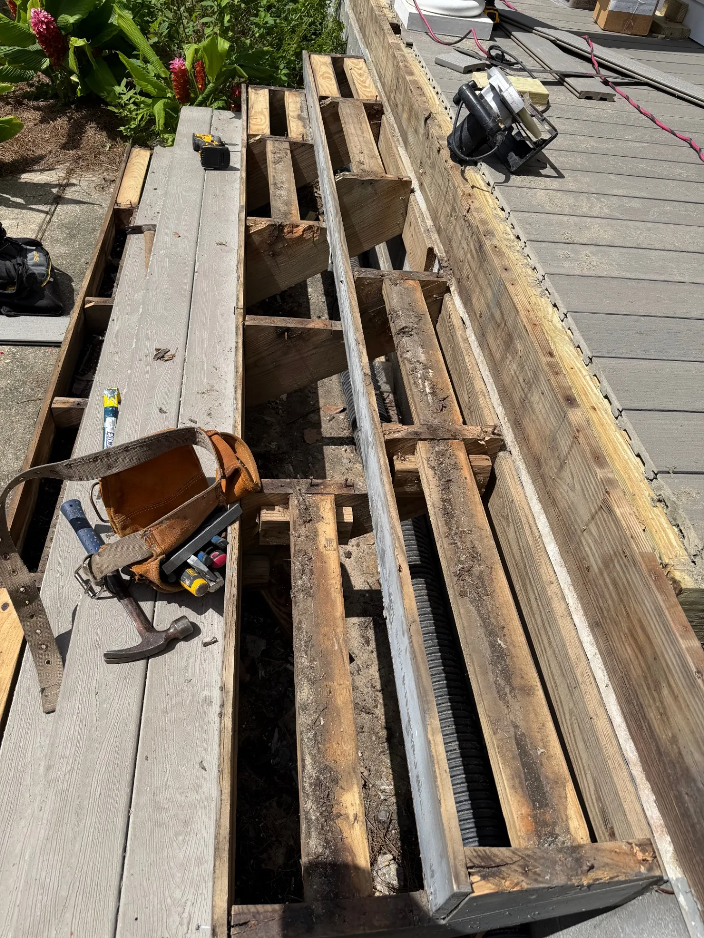Closeup of rotted floor joists and old blocking exposed after decking removal on Algiers Point front porch