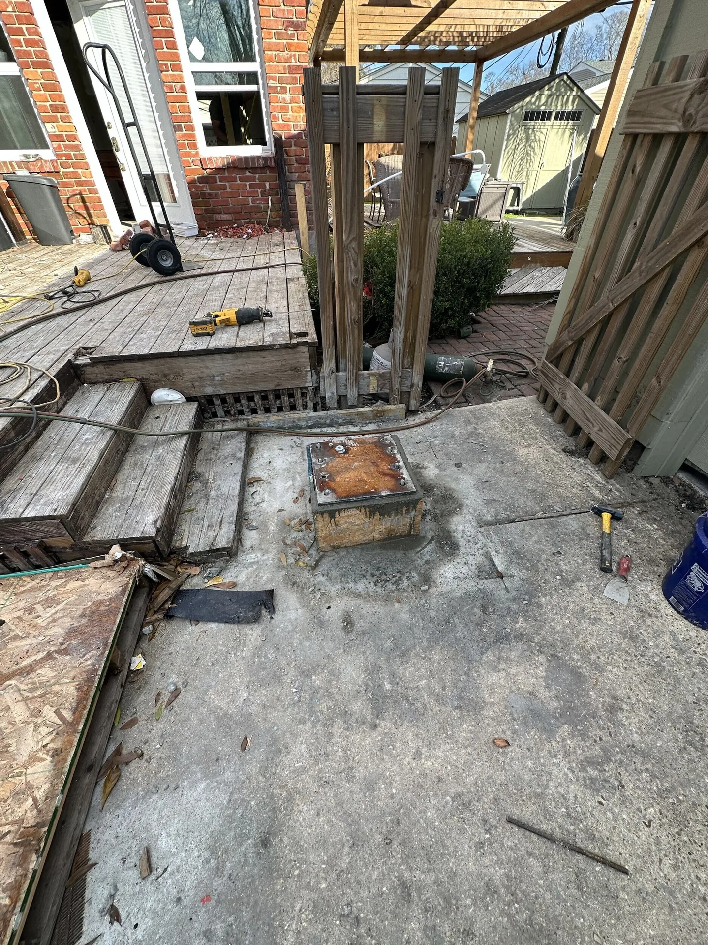 New structural steel post base plate anchored to the concrete rear patio slab at Blanke Street Metairie whole-home remodel