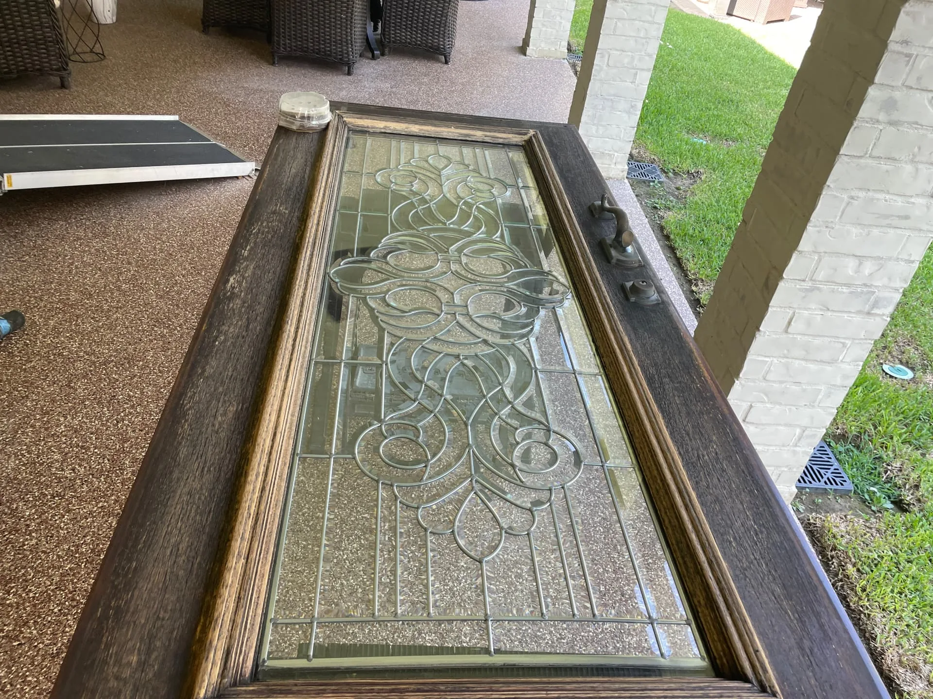 Entry door slab removed and laid flat for sanding on a Destrehan patio