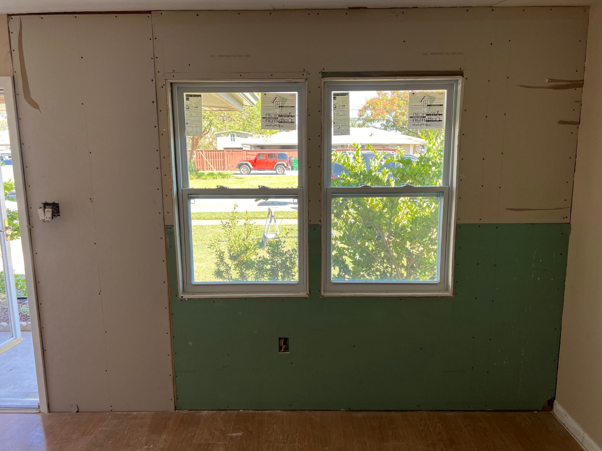 Moisture-resistant green board drywall hung around the new windows on the rebuilt Gretna wall, ready for tape and finish