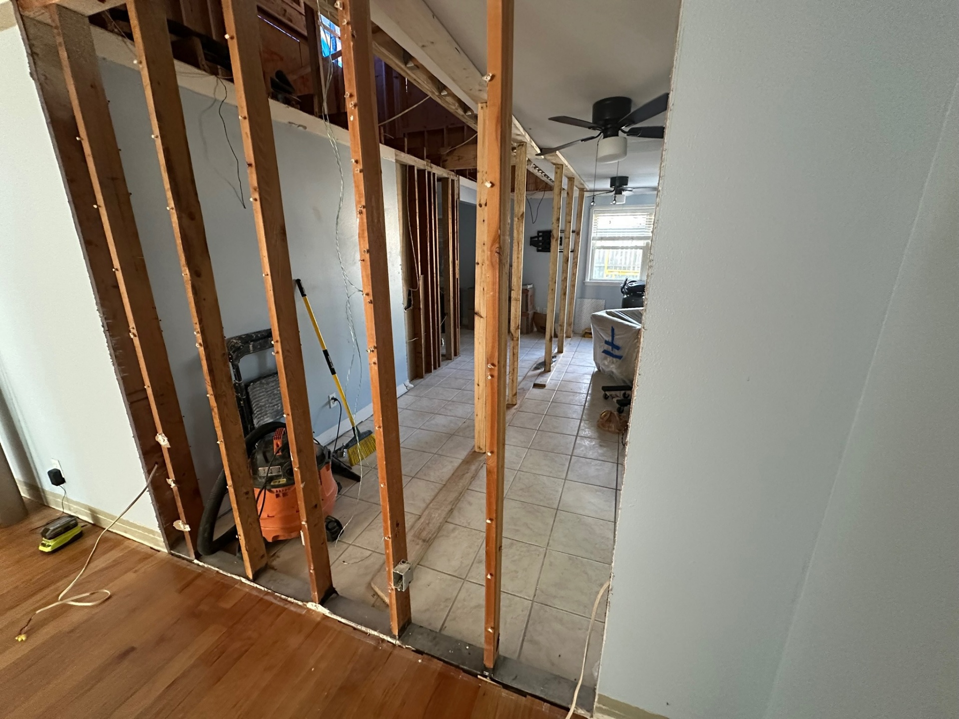 First-floor interior walls demoed to studs inside Metairie home exposing load paths before second-floor addition framing
