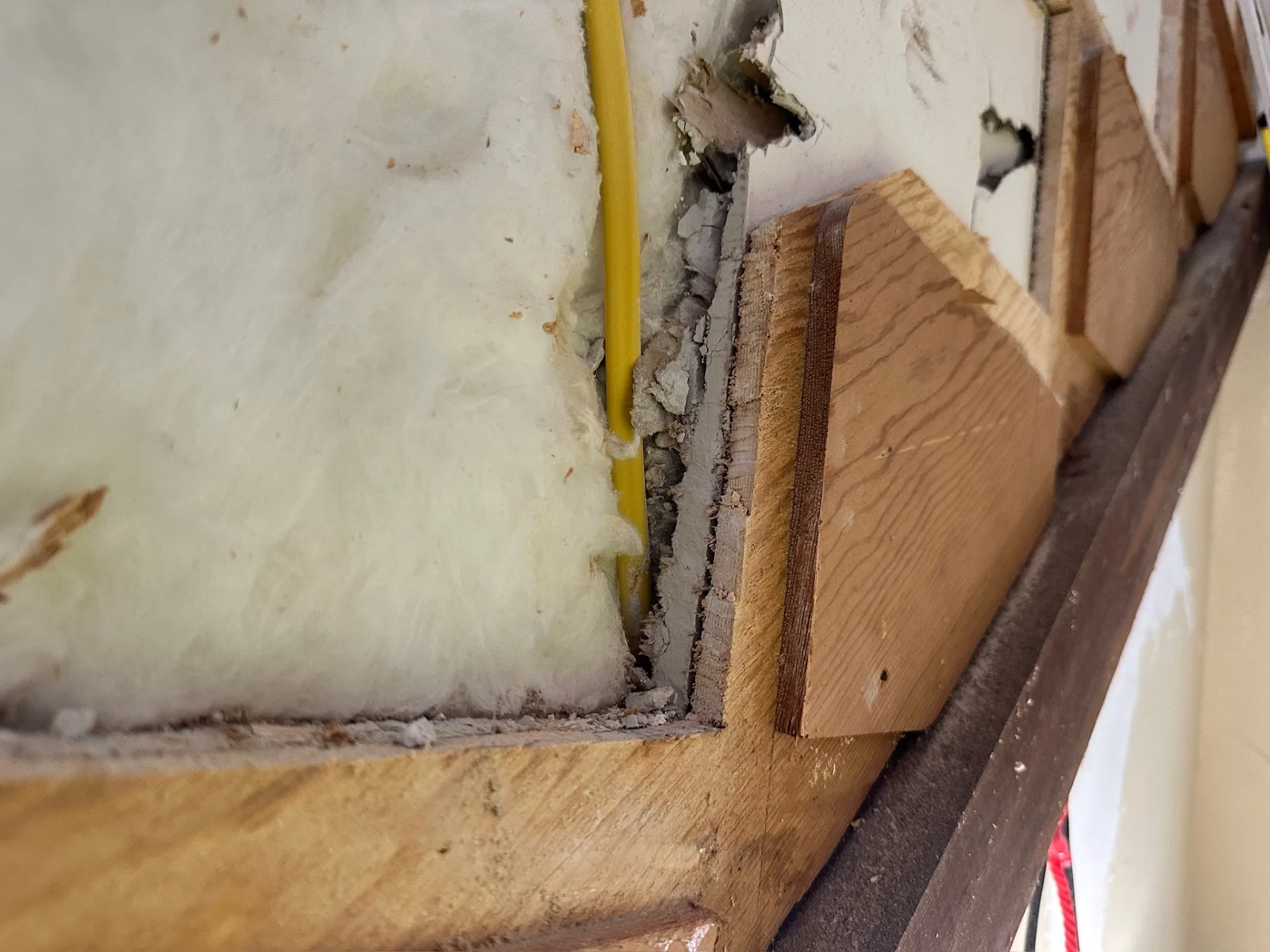 Close-up of exposed rafter and top plate where original framing meets the soffit at Blanke Street Metairie home during demo and structural inspection