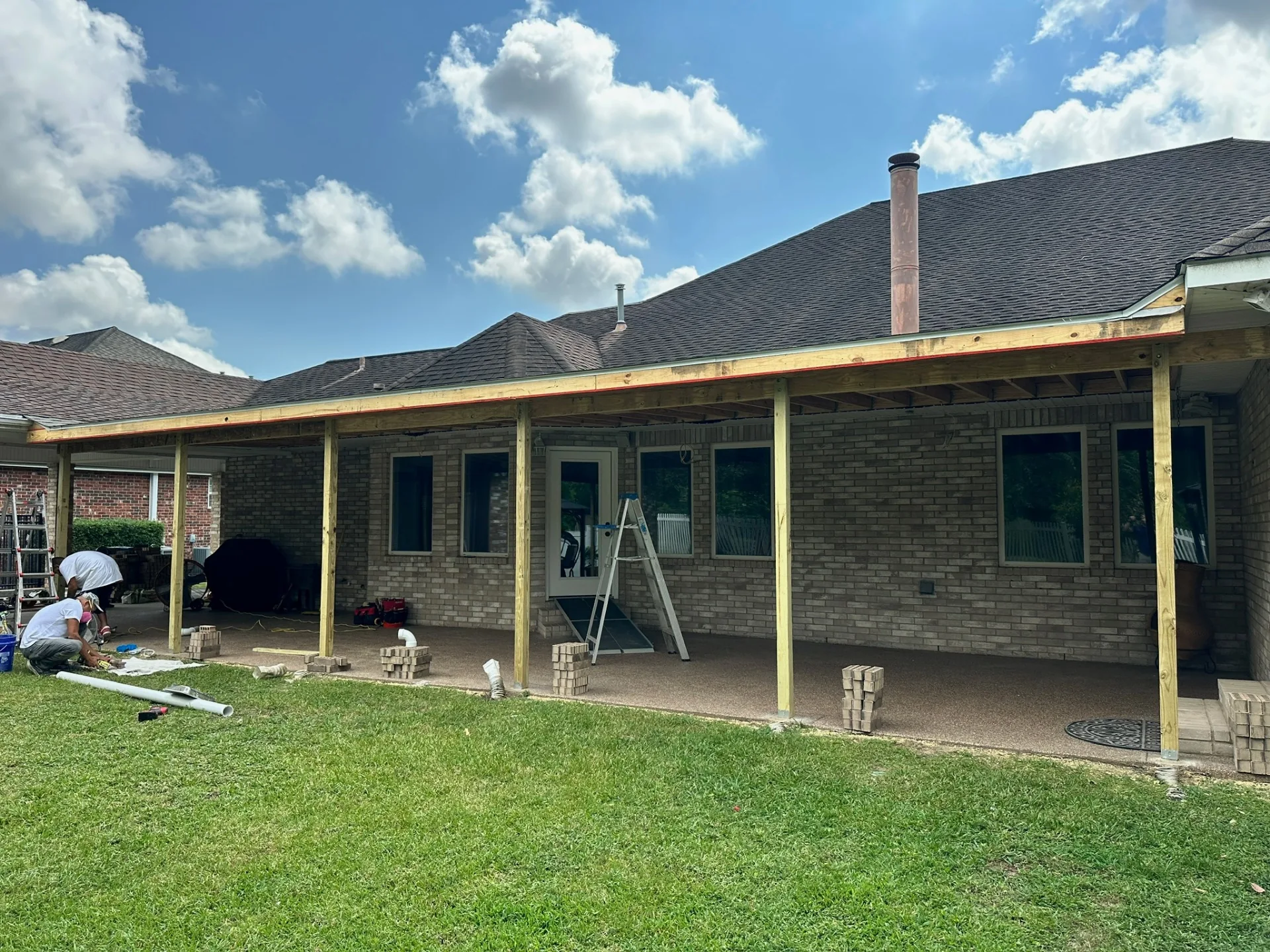 Wide rear elevation of rebuilt patio framing with new decking and posts lined out across Destrehan Louisiana home
