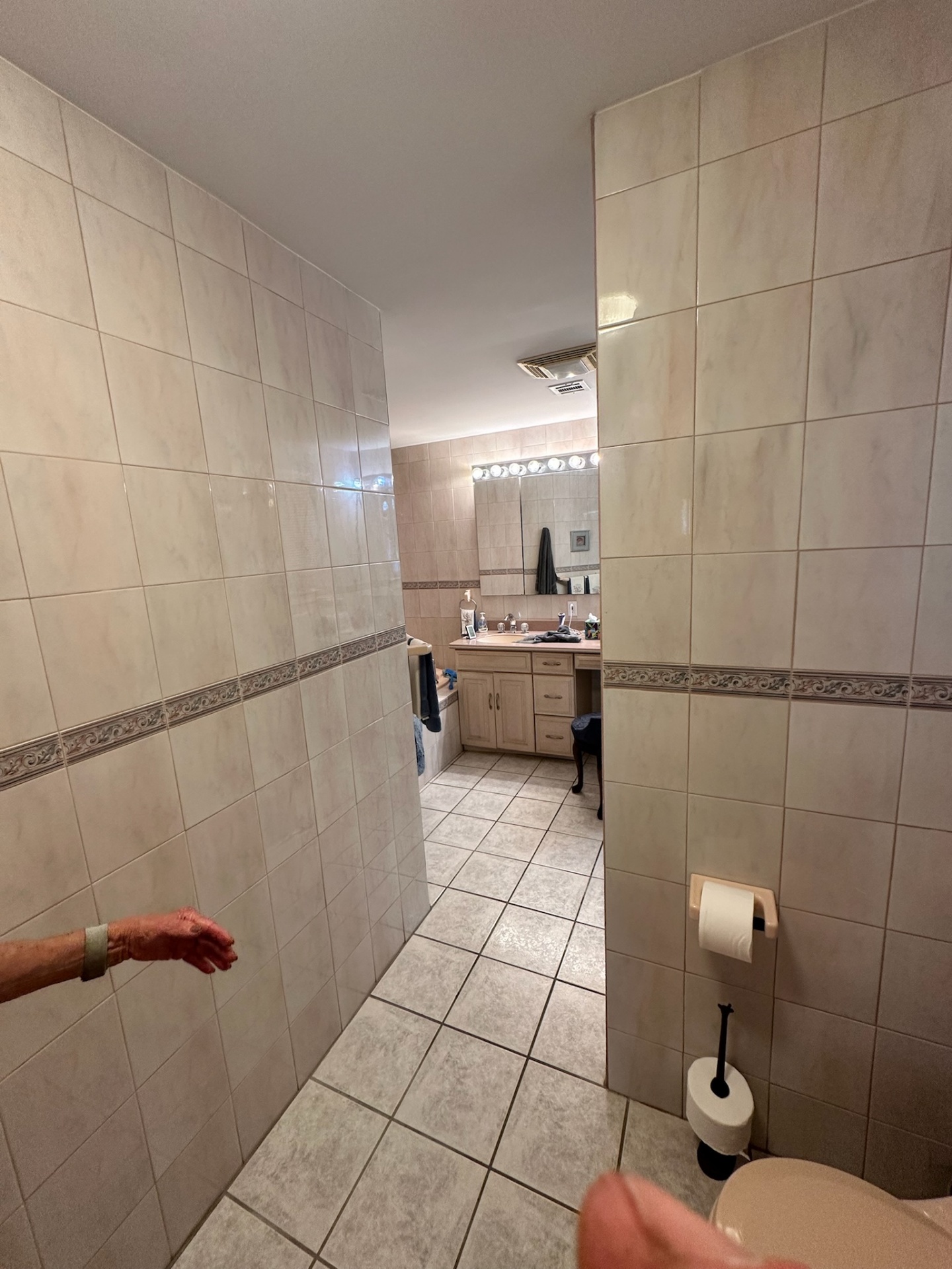 Before — dated Metairie master bathroom with peach jetted tub and cream floral border tile