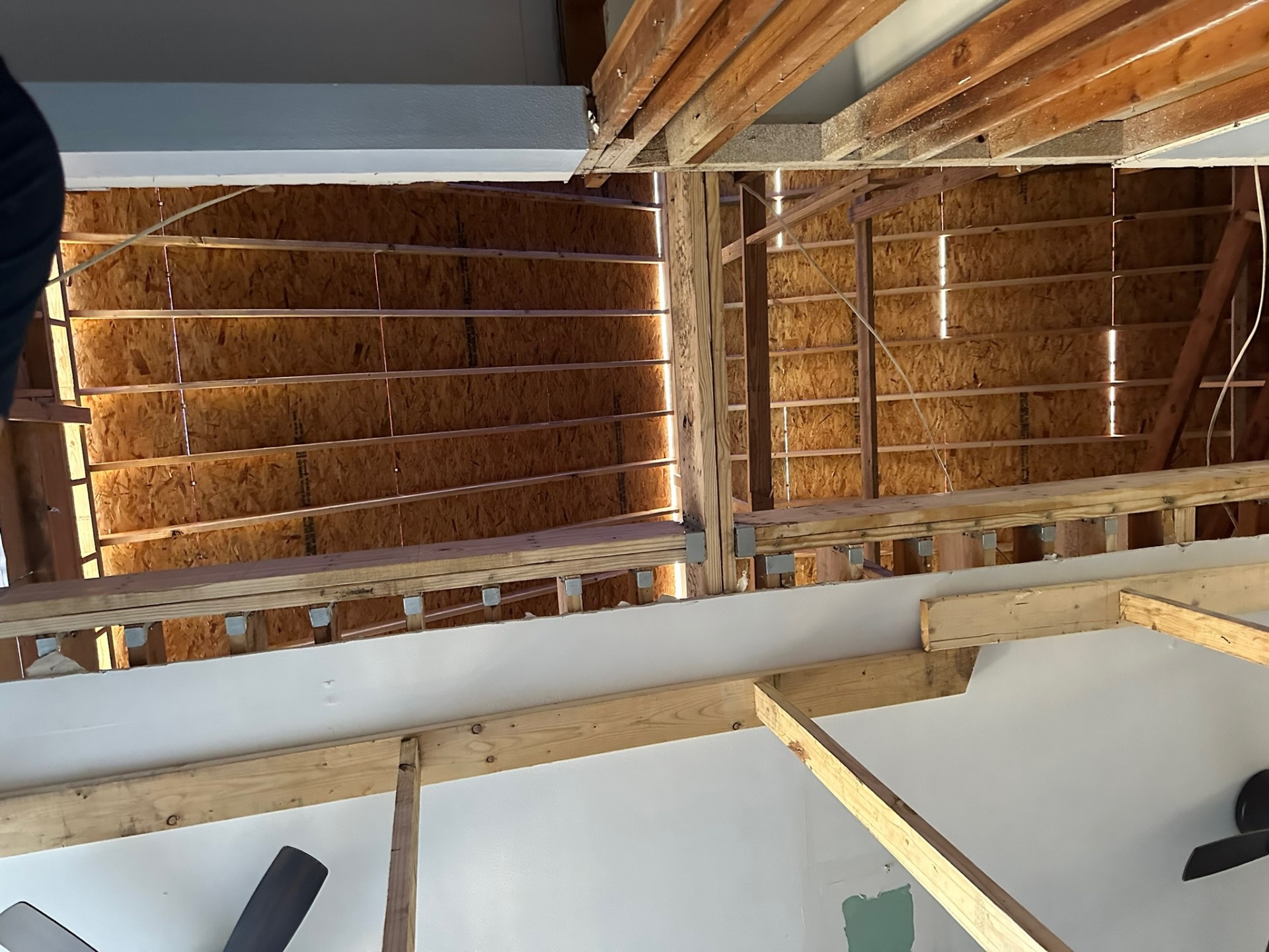 Close-up of new second-floor joists installed with Simpson Strong-Tie hangers and bolted connections on Metairie home addition
