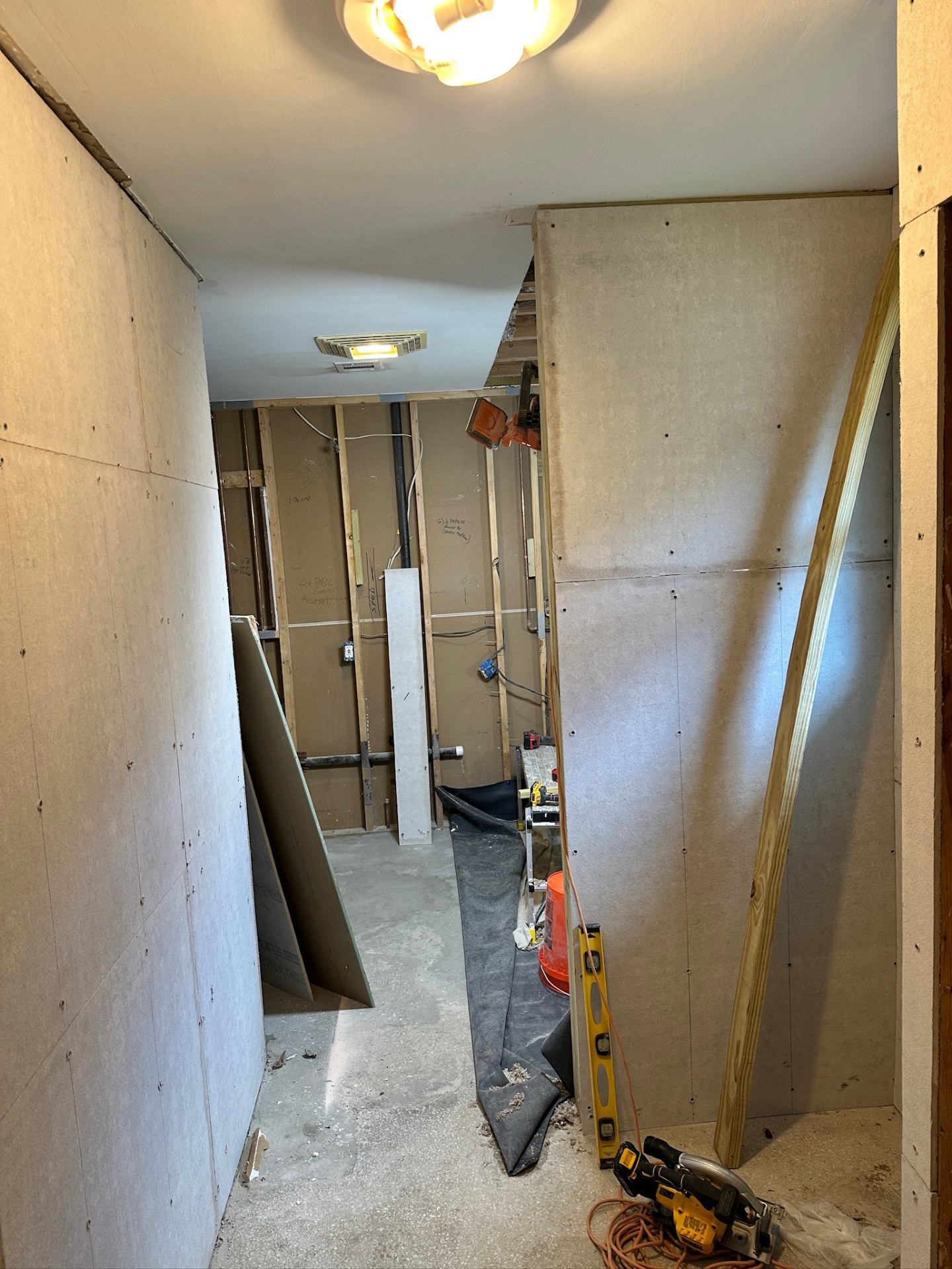 Cement backer board installed over framing in the hallway of Metairie master bath remodel