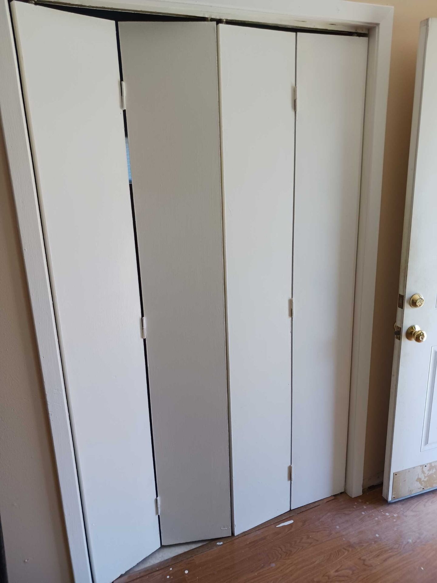 Detail of freshly repainted white bifold closet doors in the rebuilt Gretna home showing clean finish and hardware