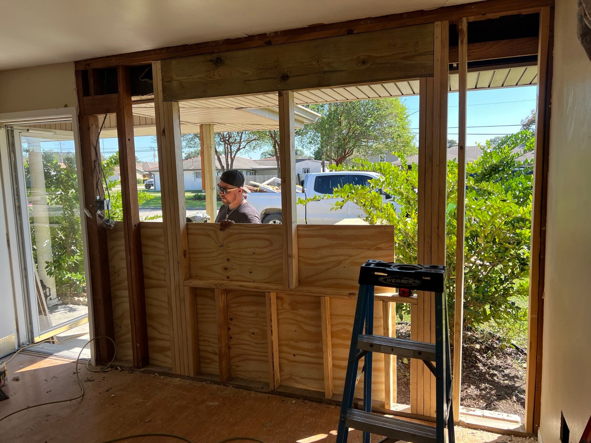 Interior view of new plywood sheathing and rough framing installed on the rebuilt exterior wall in Gretna