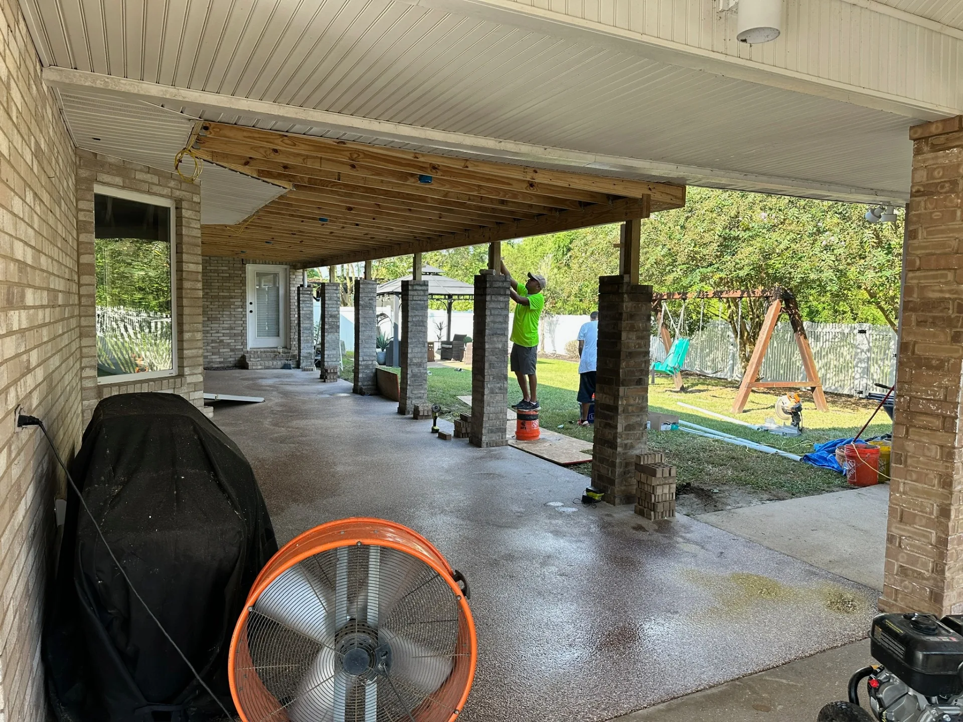 Finished vinyl beadboard soffit and completed limewashed brick-wrapped posts on rebuilt covered patio at Destrehan Louisiana home by Cajun Home Services