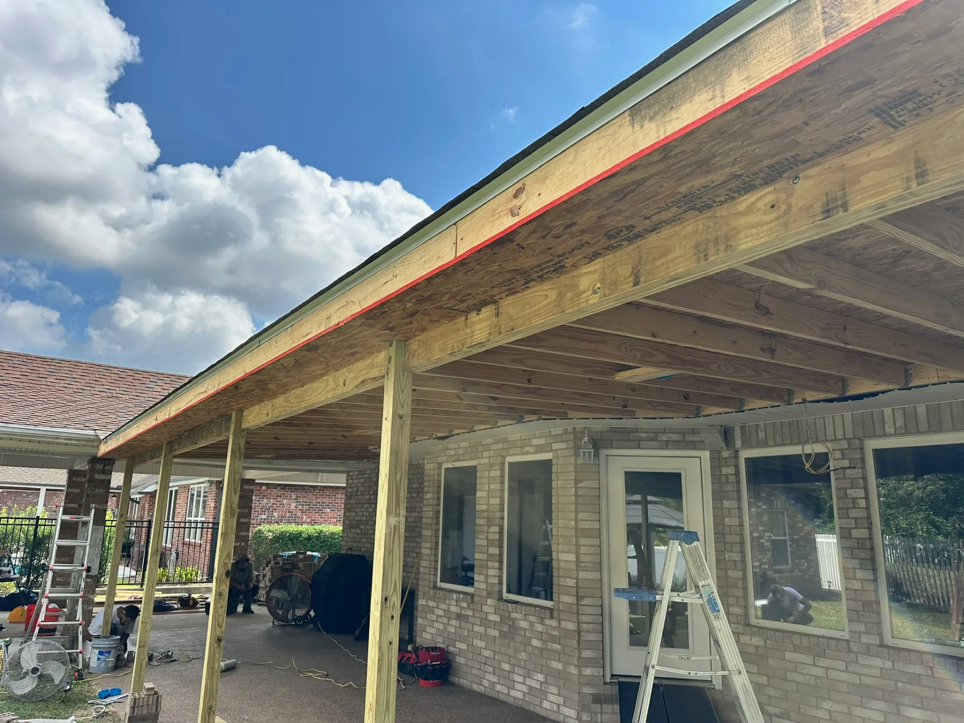 Close view of new roof edge detailing with drip edge, fascia backing, and fresh decking on rebuilt covered patio at Destrehan Louisiana home
