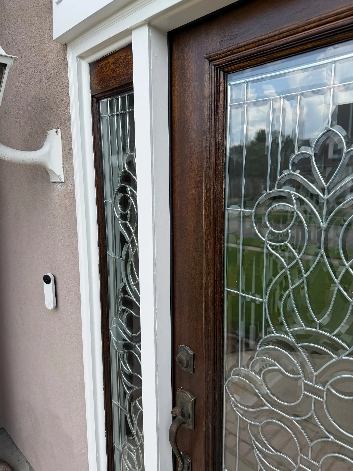 Close-up of refinished sidelight with beveled glass and fresh white trim in Destrehan Louisiana