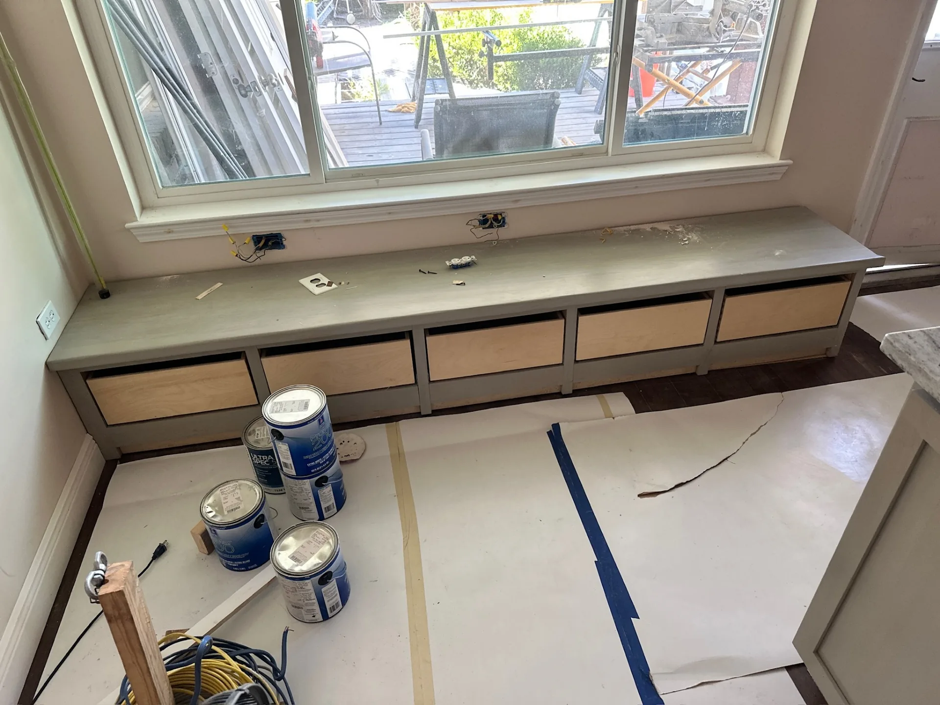 Breakfast nook banquette bench under new picture window at Blanke Street Metairie home, built-in drawer bases primed and ready for finish paint