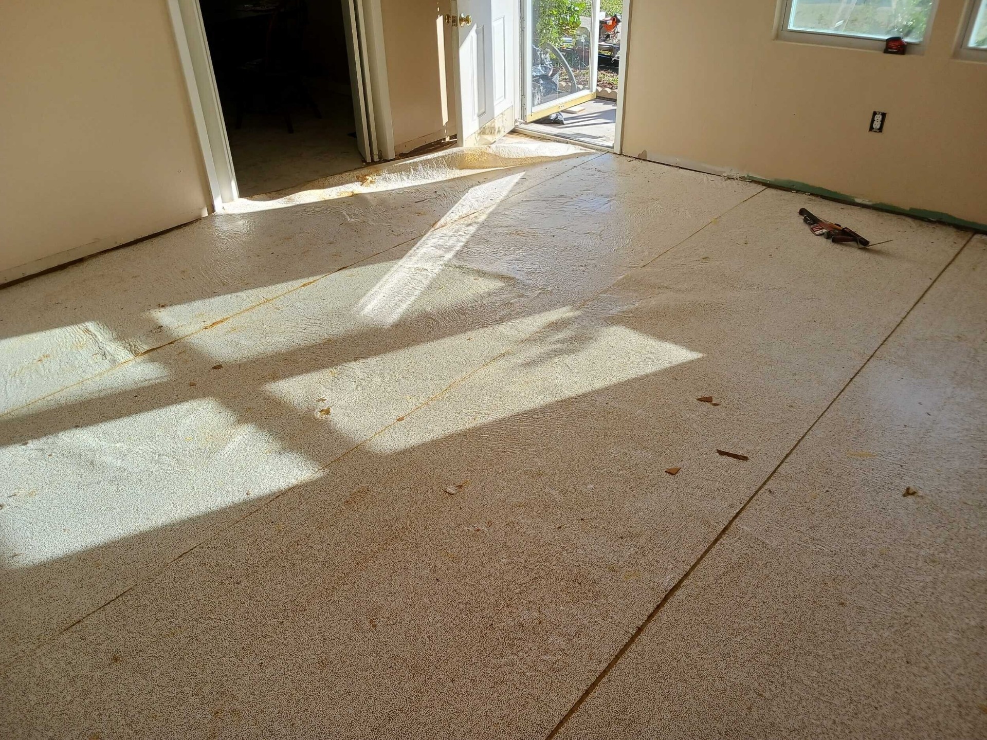Subfloor prepared with plywood underlayment across the main living area of the Gretna home ready for new laminate flooring installation