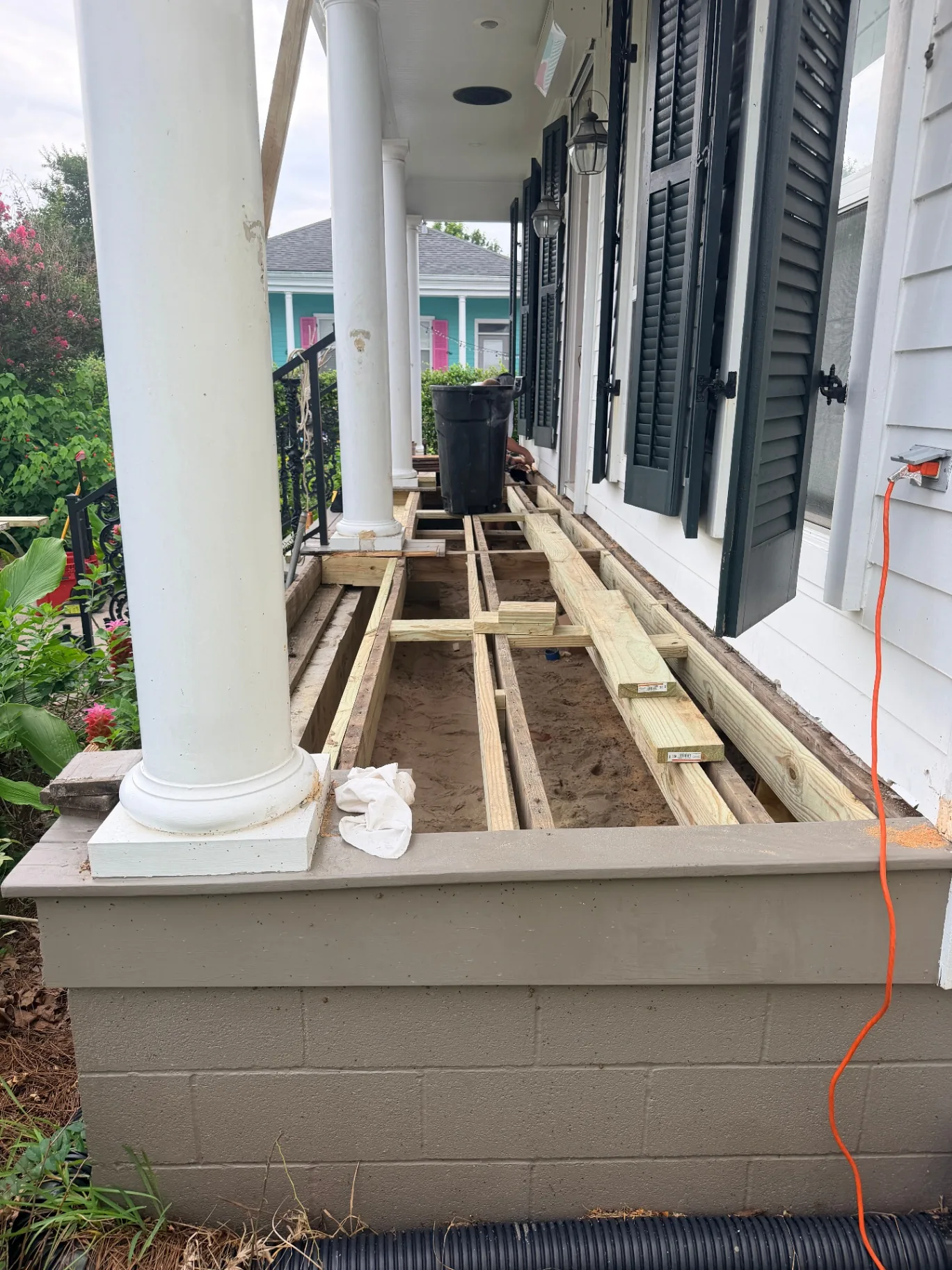Framing — new pressure treated joists sistered to existing framing under Algiers Point porch rebuild