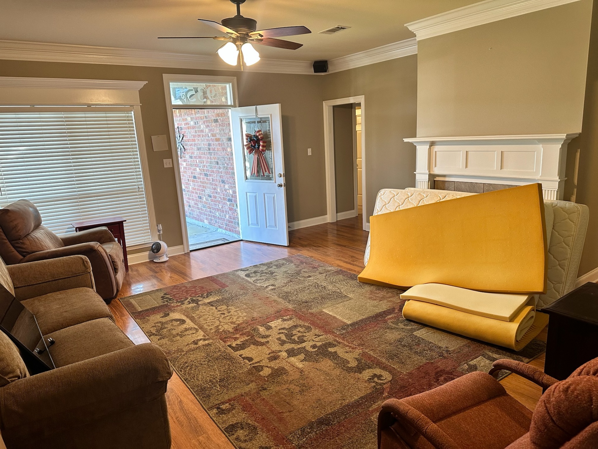 Before — living room with worn hardwood floor and furniture in Gonzales Louisiana