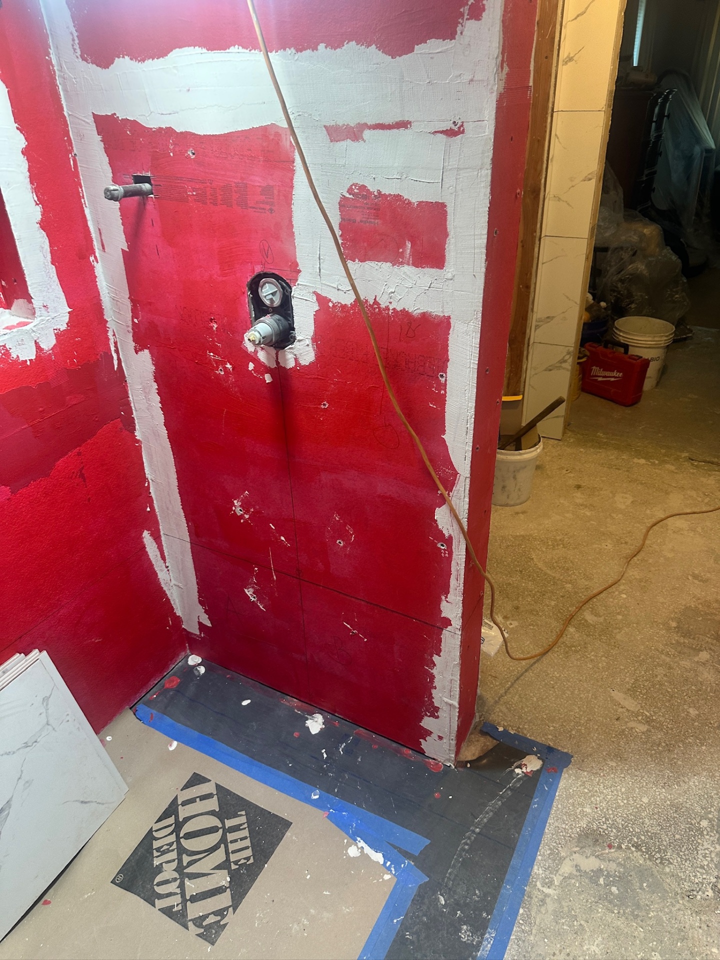 Schluter Kerdi shower curb and RedGard-coated walls at the walk-in shower entry in Metairie master bath