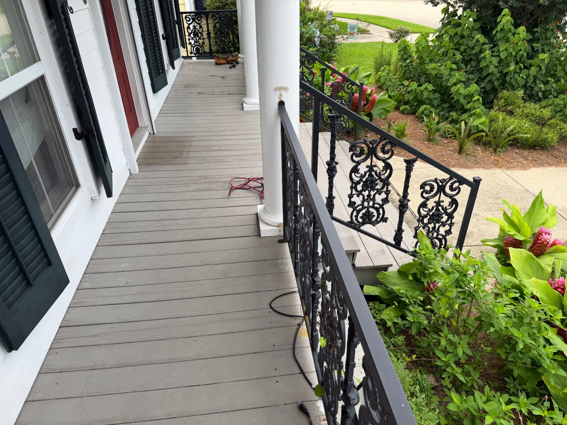 Before — worn painted wood porch decking along side elevation at Algiers Point home