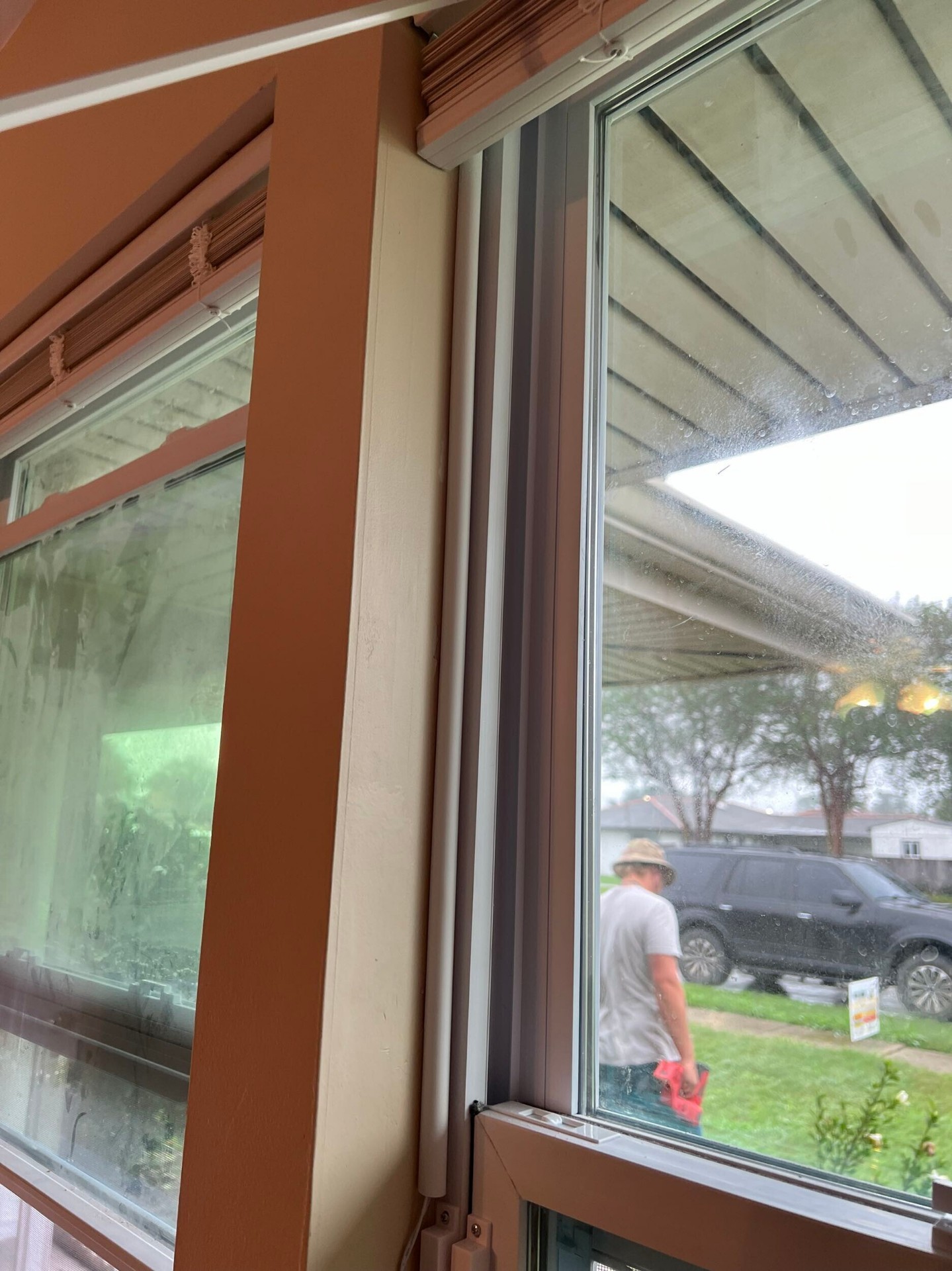Interior finished view of the new double-hung window with clean paint, trim, and a clear view to the finished porch on the Gretna rebuild