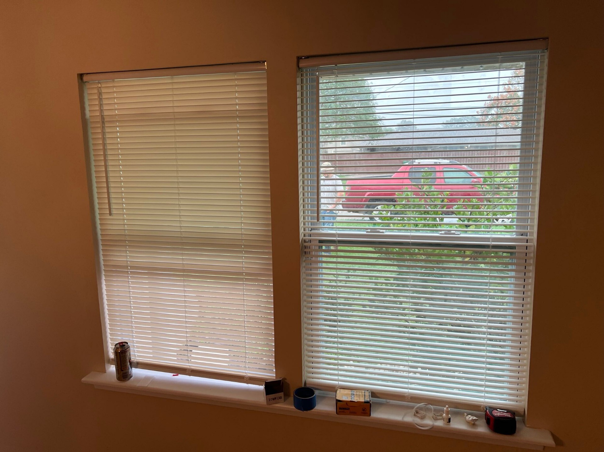 Existing white horizontal blinds rehung on the two new front windows in the rebuilt Gretna living room