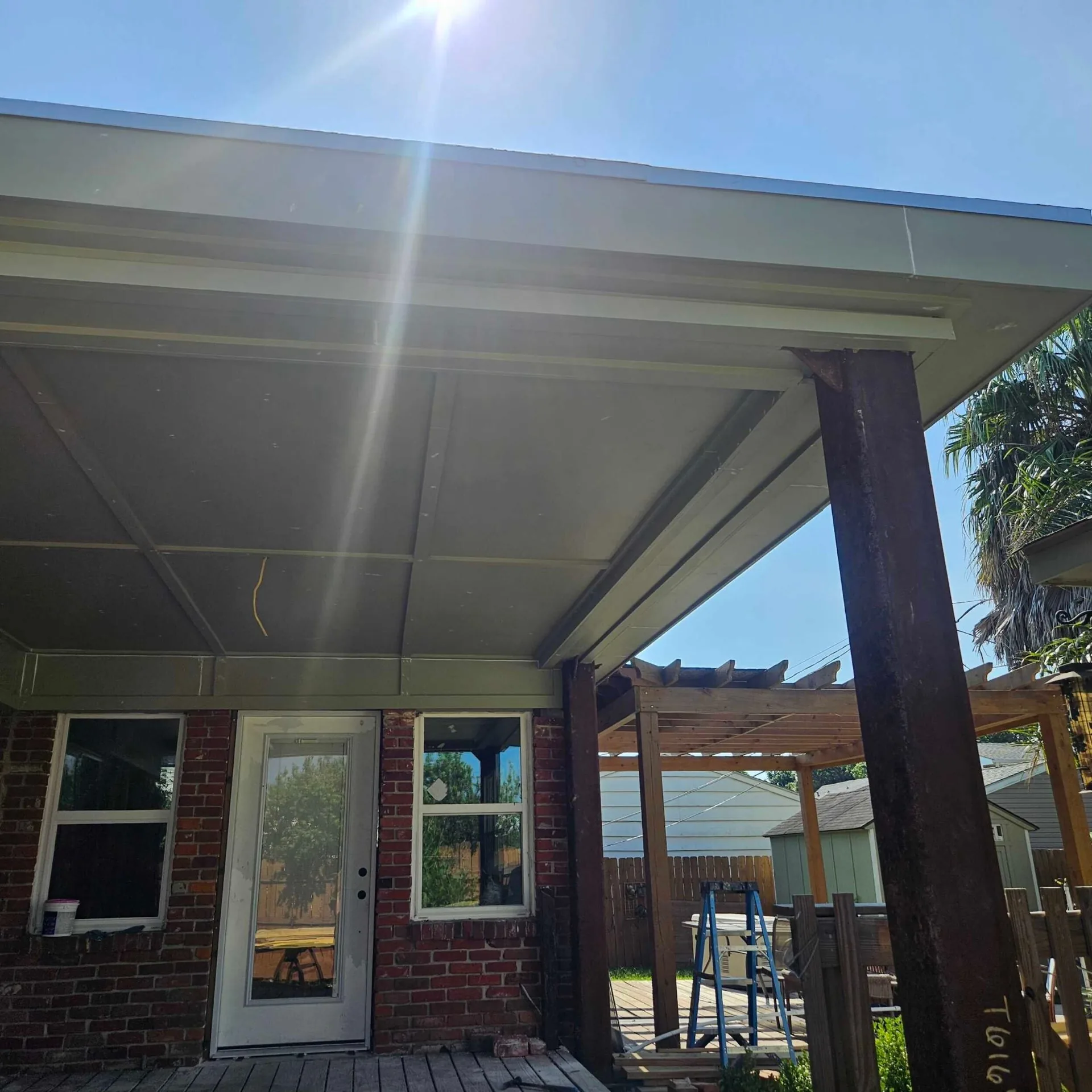 Rebuilt covered porch at Blanke Street Metairie home with new vinyl beadboard ceiling in primer and cedar posts still in place before finish paint