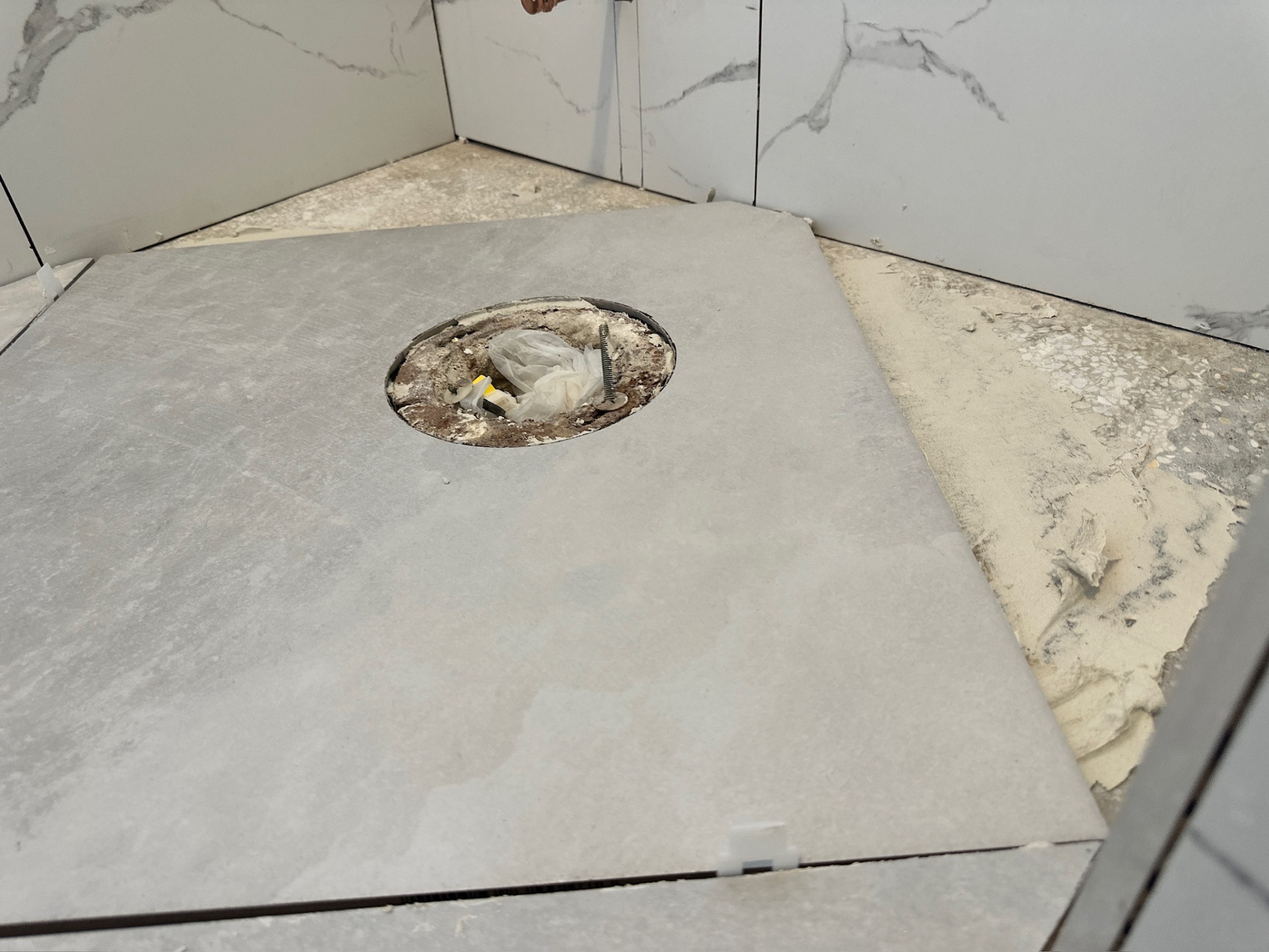 Precise circular tile cut around the toilet flange on the diagonal floor tile in Metairie master bath