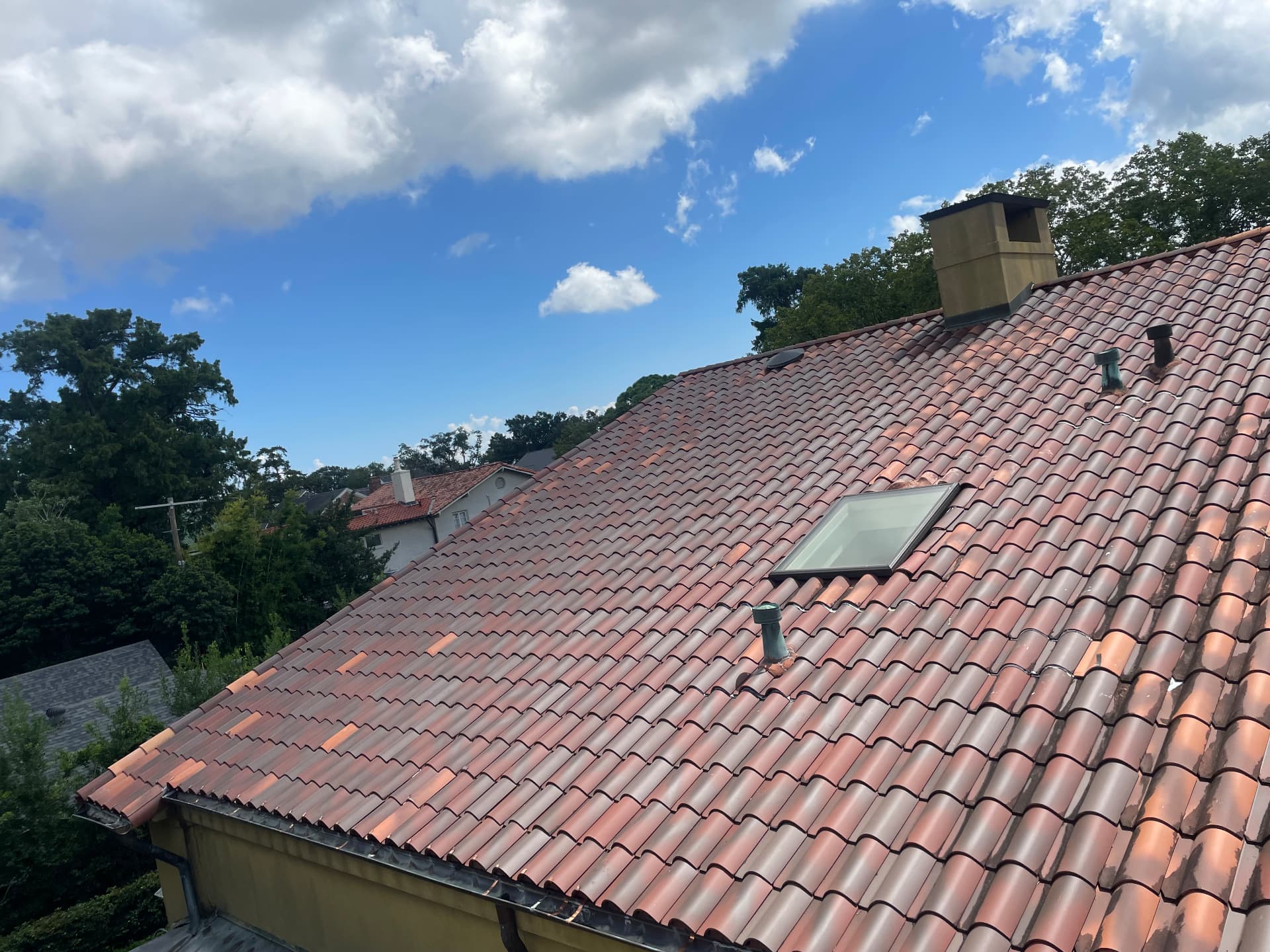 Finished terra cotta barrel tile roof with skylight and chimney after repairs in Northline Metairie Louisiana