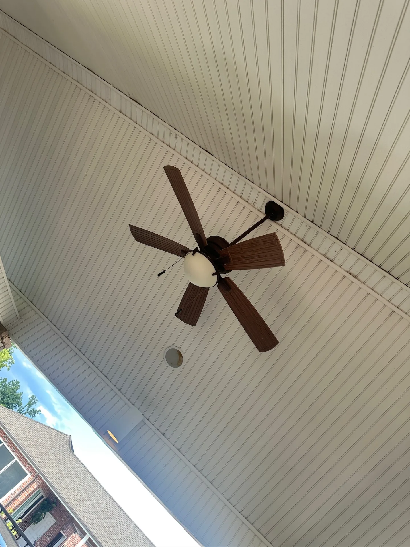Close-up detail of aged vinyl soffit and beadboard patio ceiling on Destrehan Louisiana home before replacement