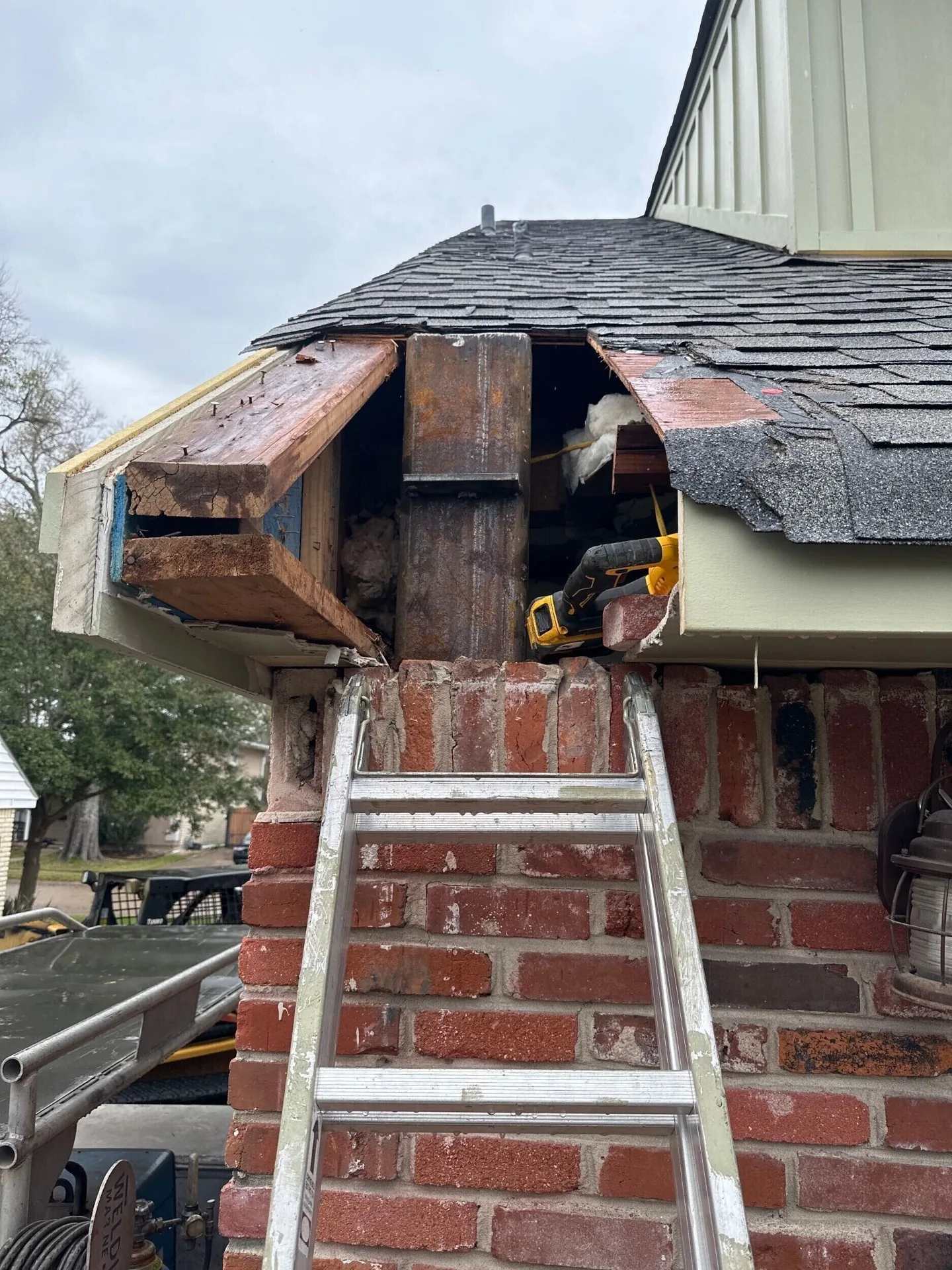 Close-up detail of new structural steel column tied into the existing brick wall at the roofline of Blanke Street Metairie home remodel