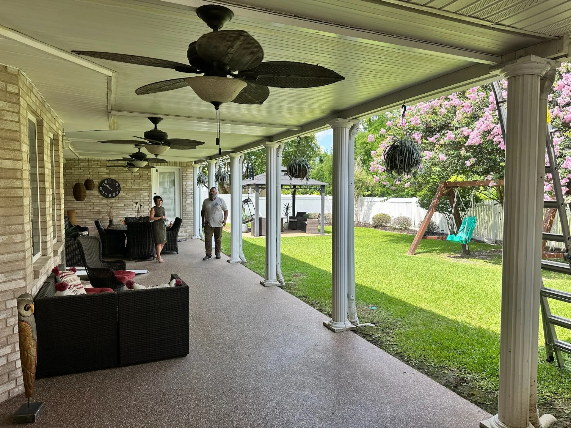 Homeowners under the existing aged covered patio at Destrehan Louisiana home during pre-construction walkthrough with Cajun Home Services