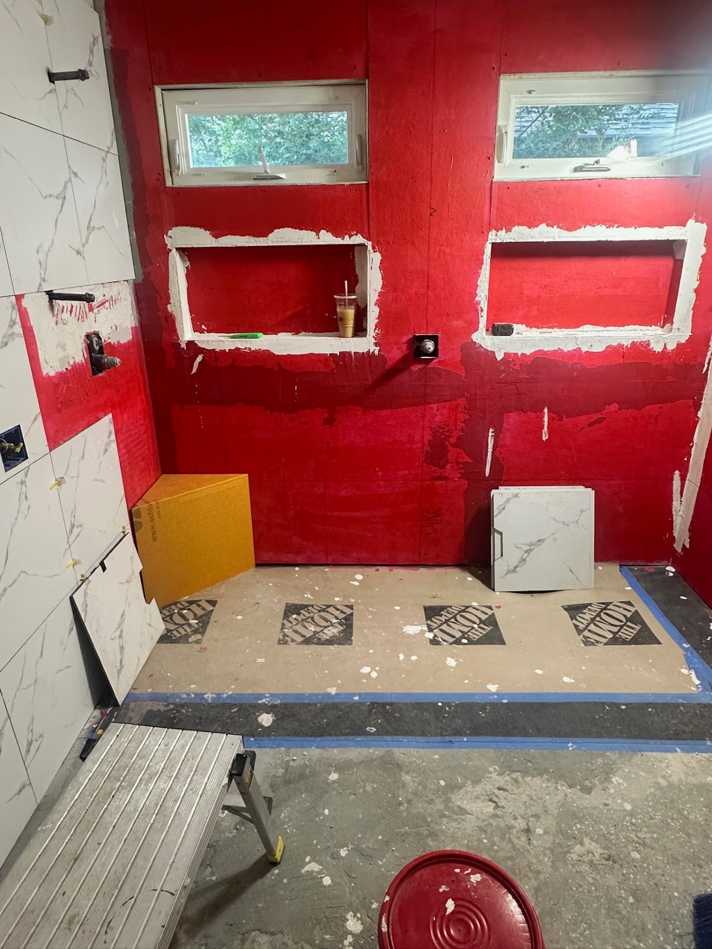 RedGard waterproofing applied to shower walls with two framed niches and dual awning windows in Metairie master bath