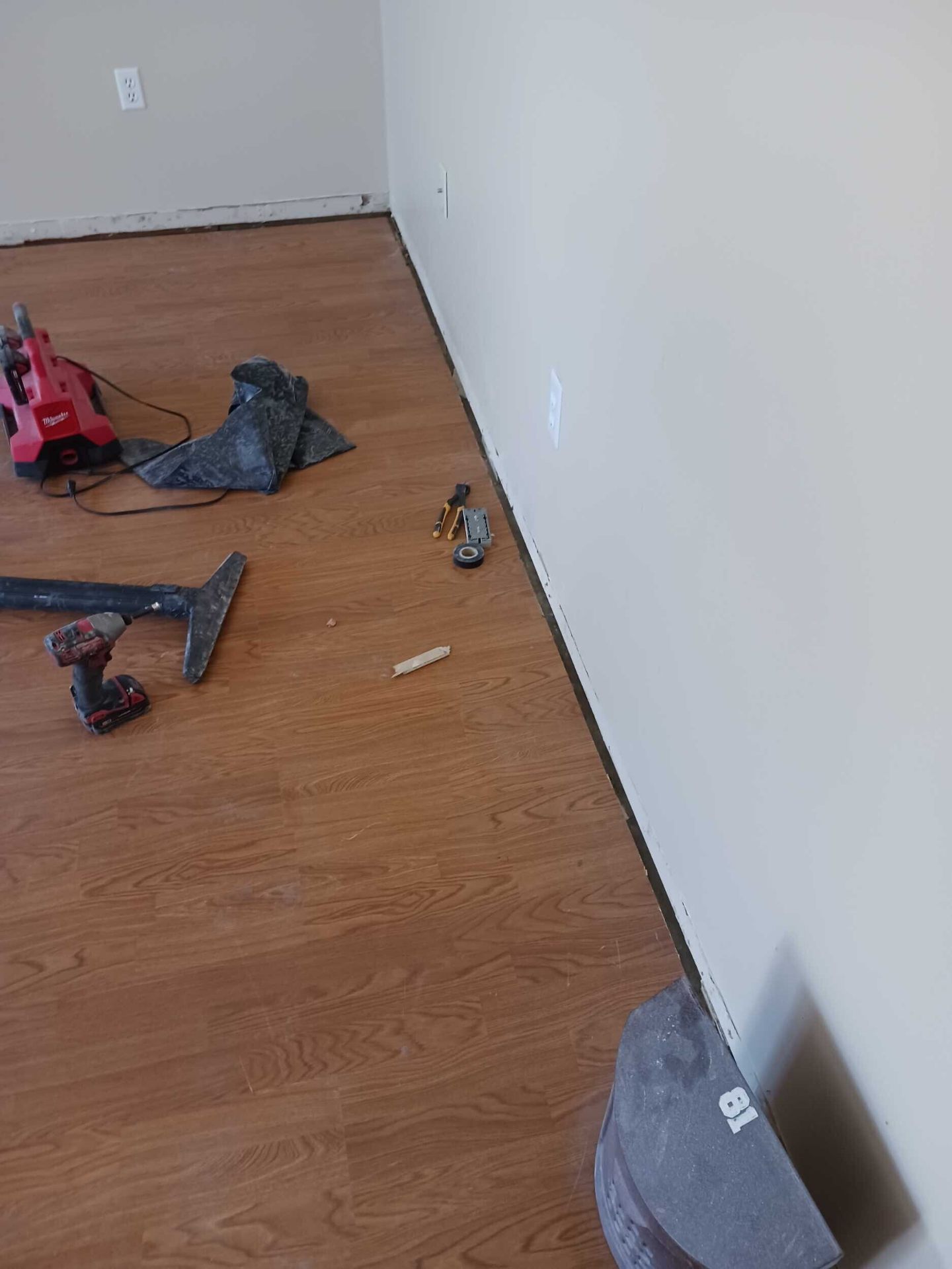 Interior of the rebuilt Gretna room with fresh paint, new baseboards, and clean wood-look flooring during final finish work