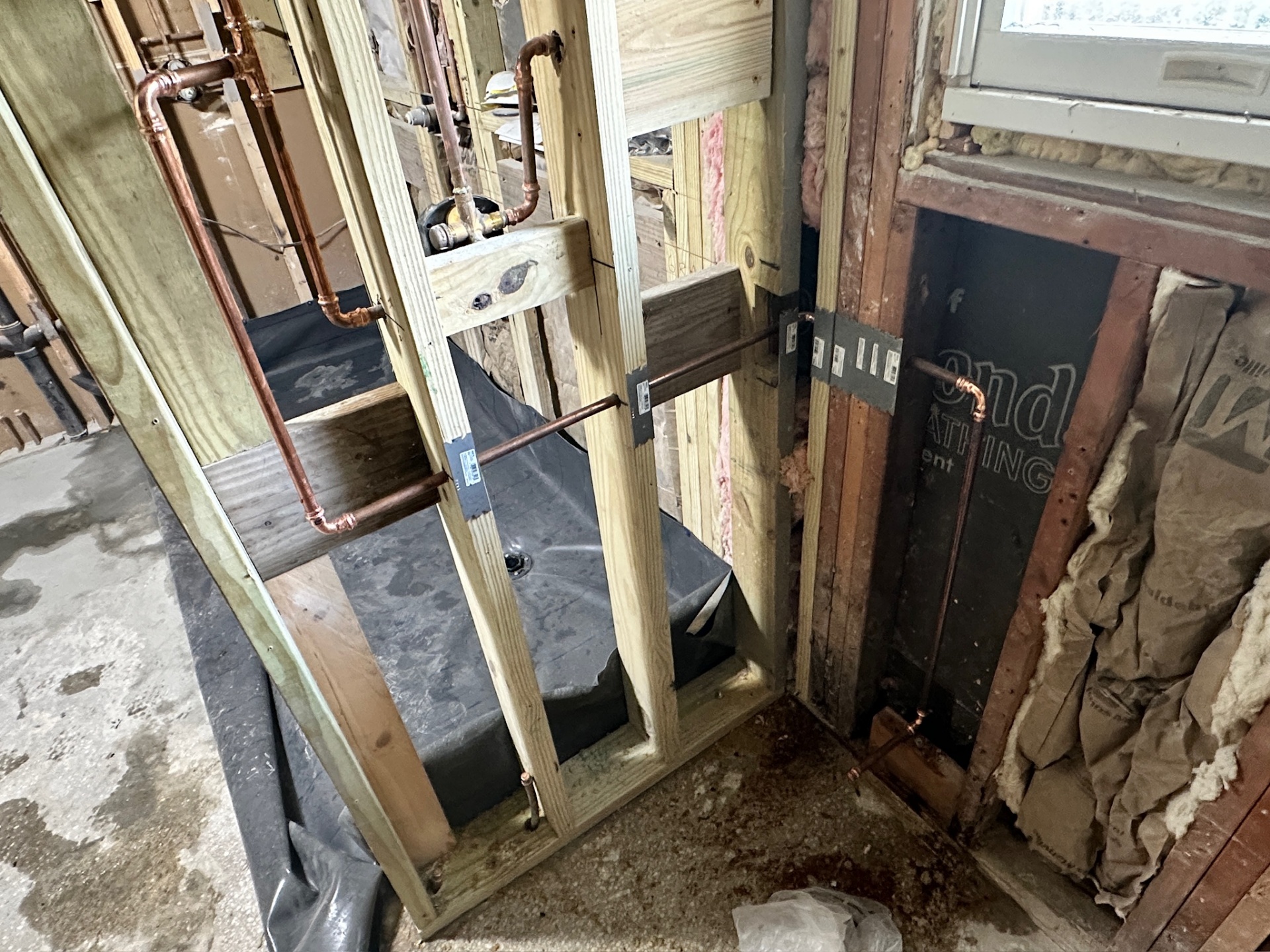 Rubber shower pan liner installed and folded up the walls with copper supply lines in Metairie master bath