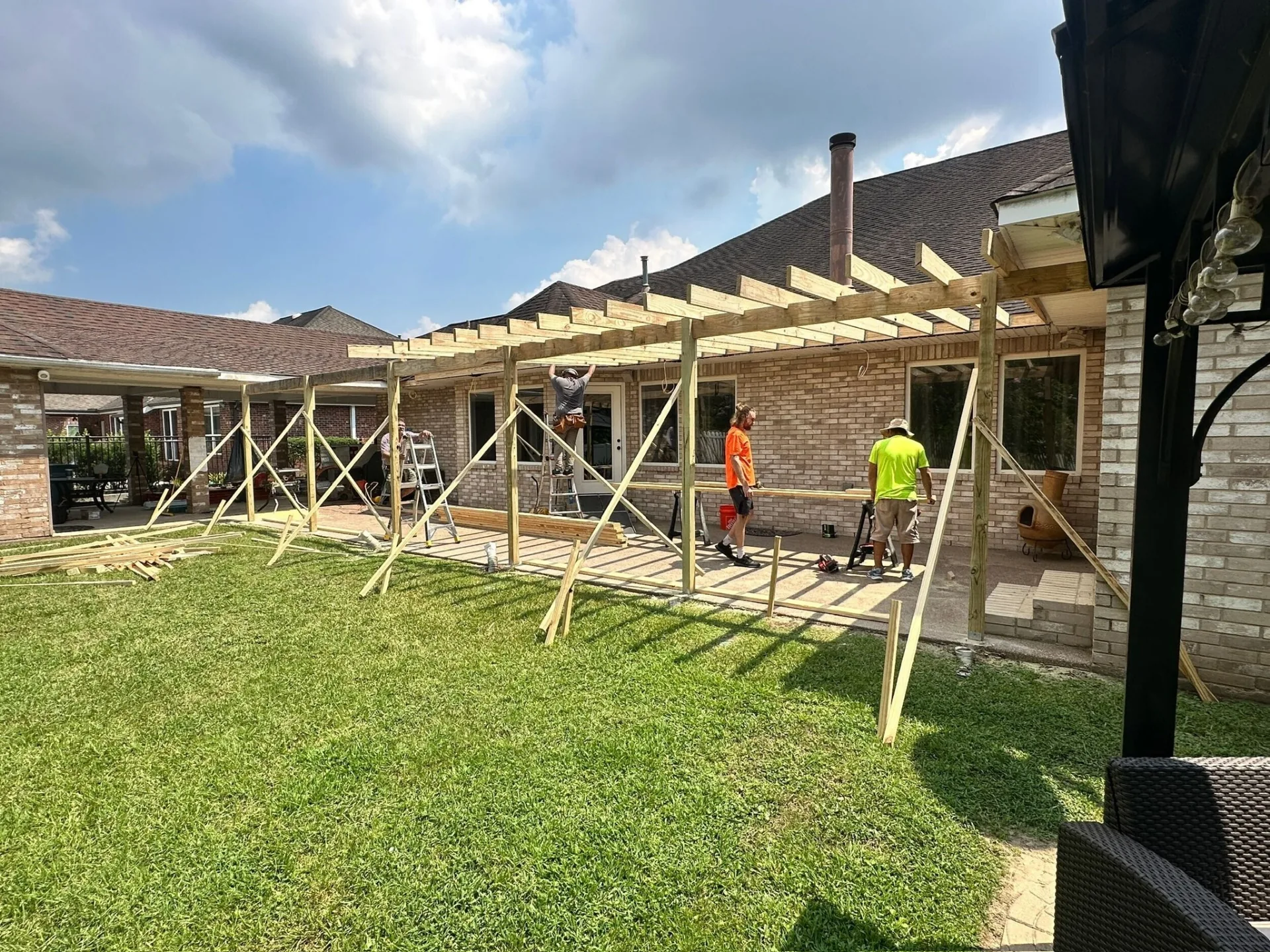 Cajun Home Services crew installing new pressure-treated framing for complete covered patio replacement at Destrehan Louisiana home