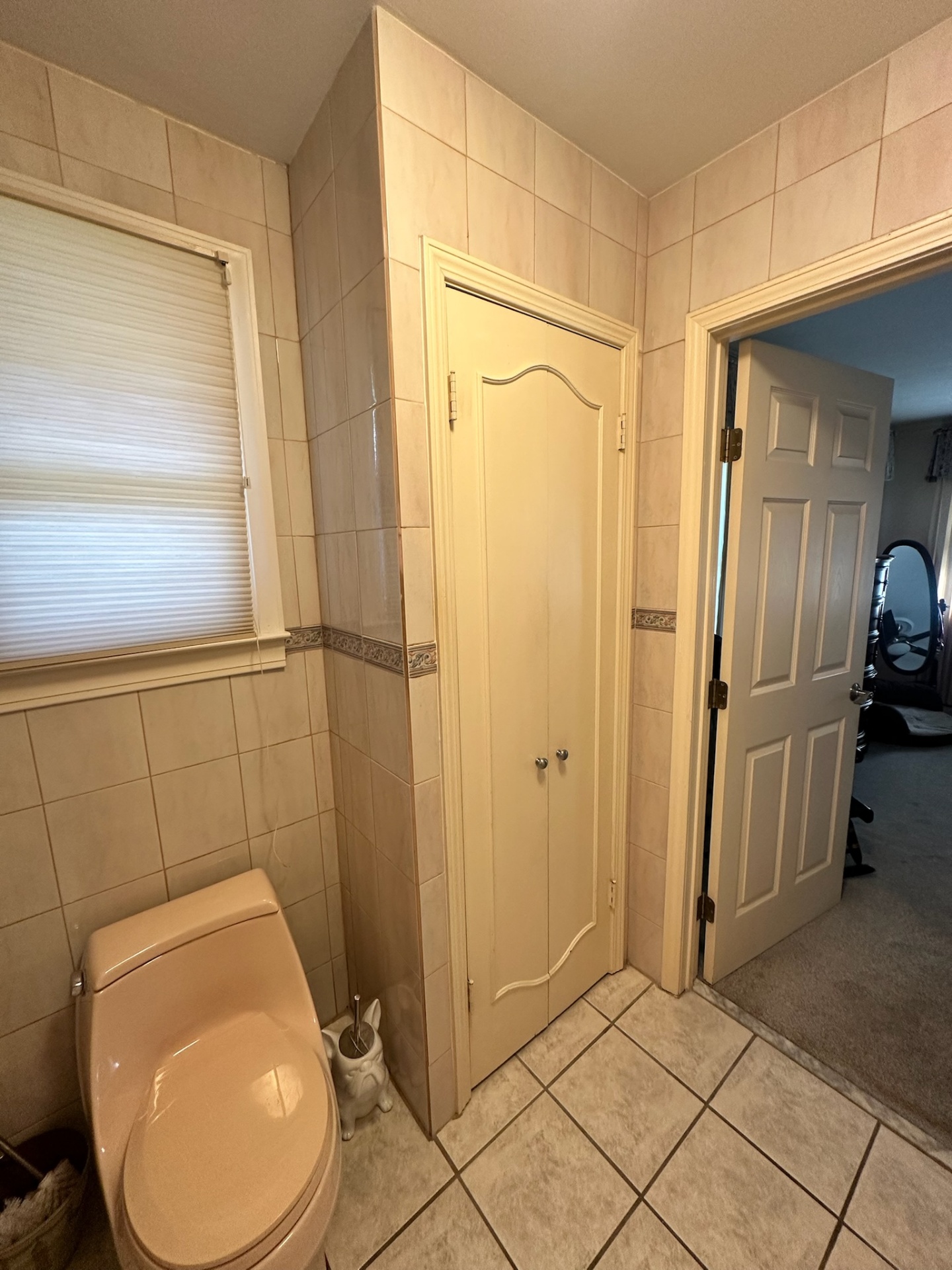 Before — separated toilet room with arched linen closet and peach toilet in Metairie master bath