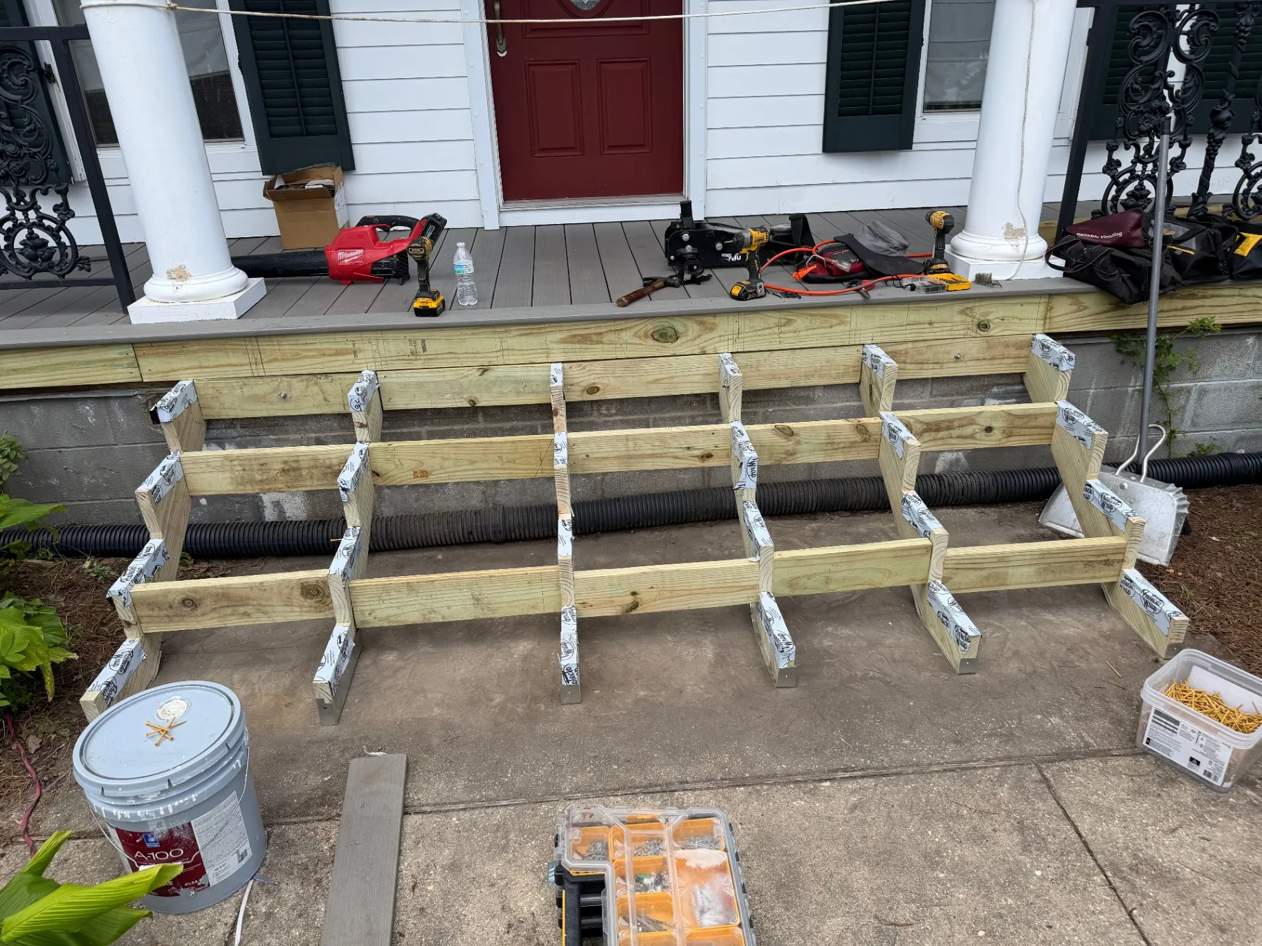 Front view of new pressure-treated stair stringers set against porch rim board with Protecto Wrap detail at Algiers Point home